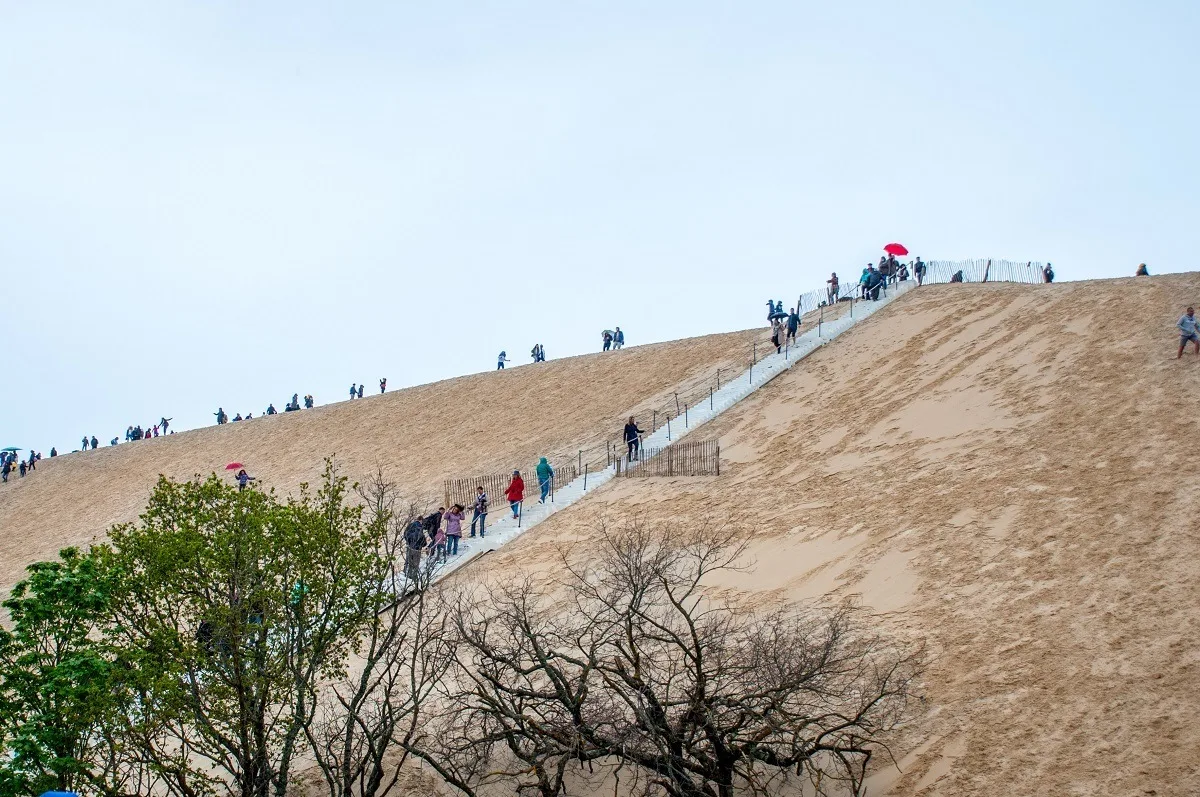 People climbing a giant sand dune