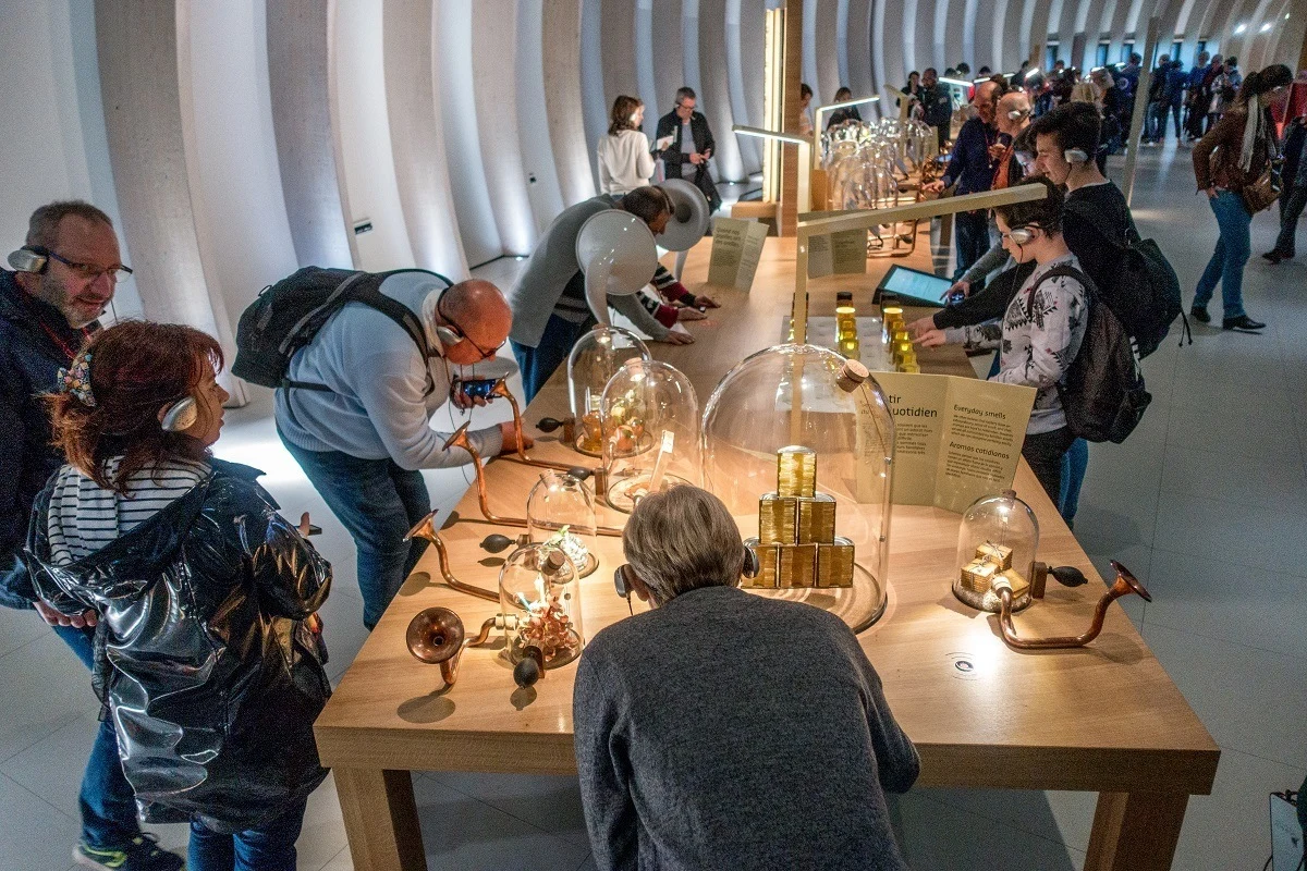 Visitors smelling wine aromas at a museum.