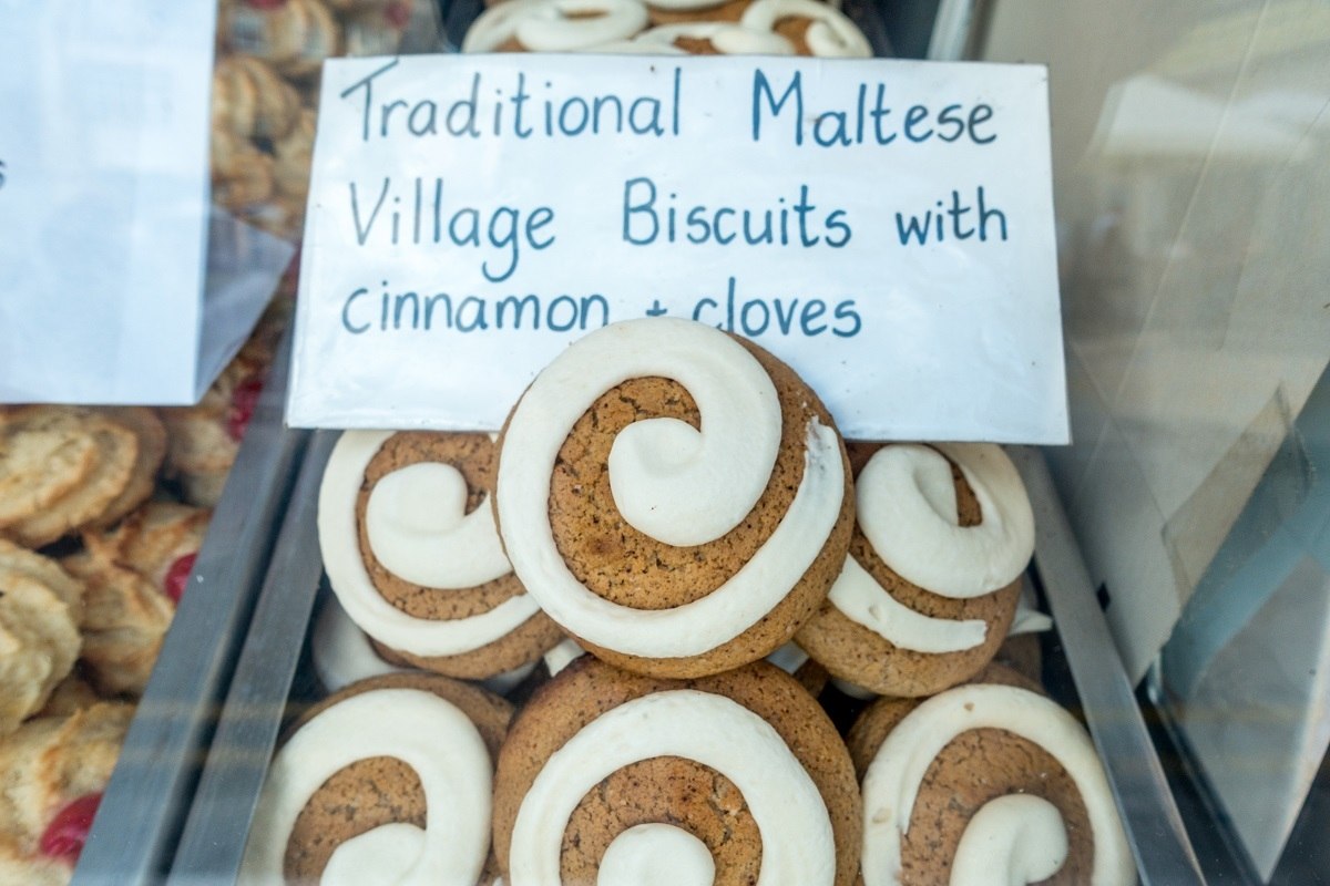 Cookie topped with icing and a sign: Traditional Maltese Village Biscuits with cinnamon & cloves.