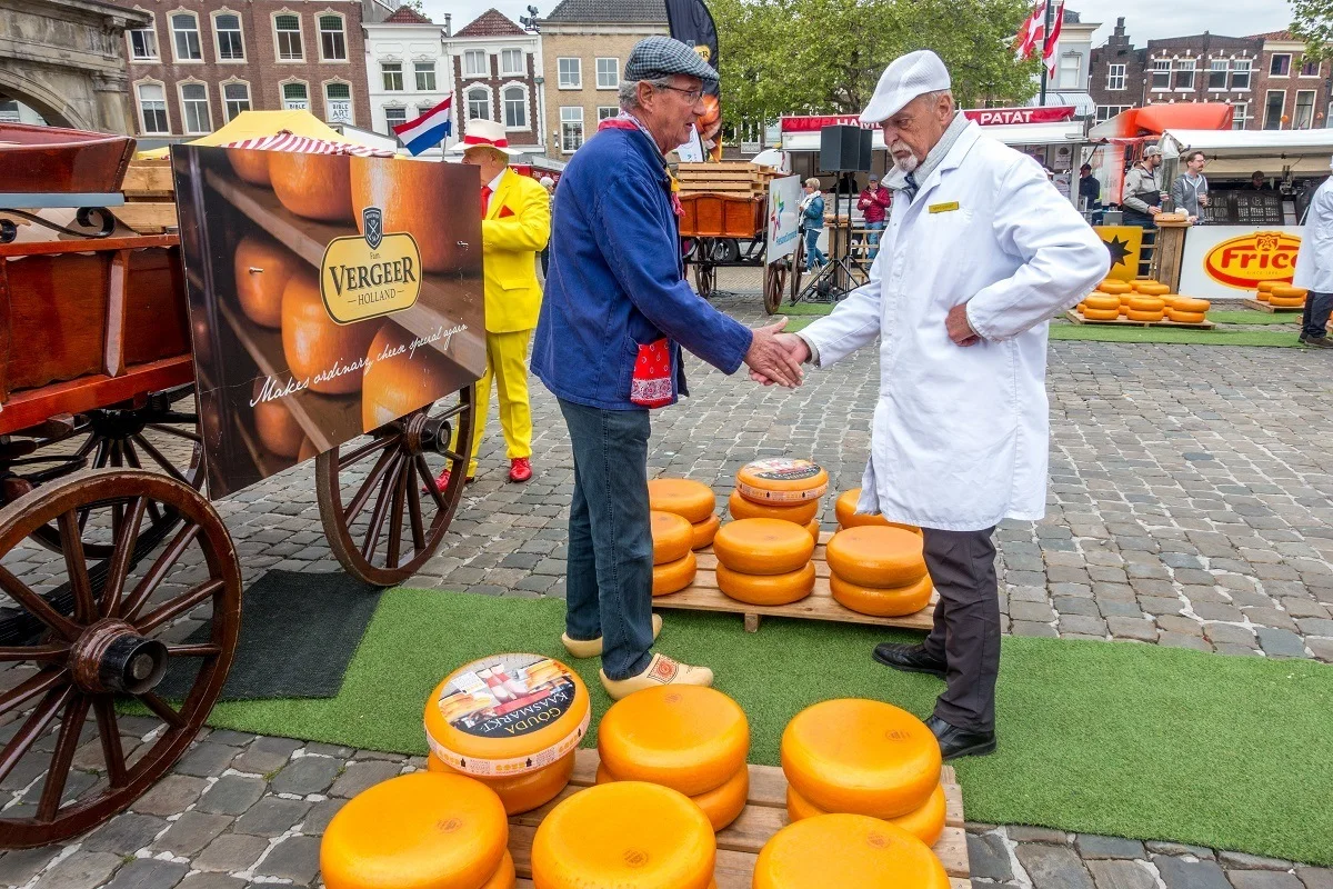 Men shaking hands while negotiating cheese prices