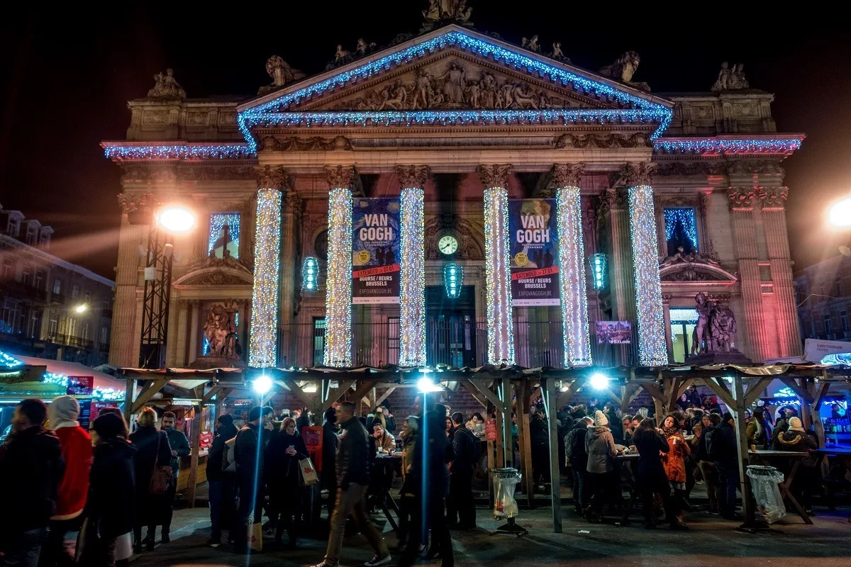 Building with columns and market stalls lit up in Brussels
