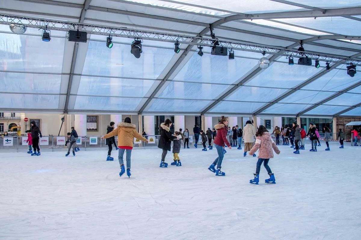 People skating on covered ice skating rink