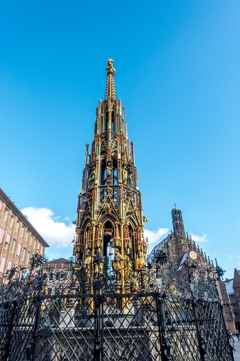Golden spire-shaped fountain ringed by 40 figurines 