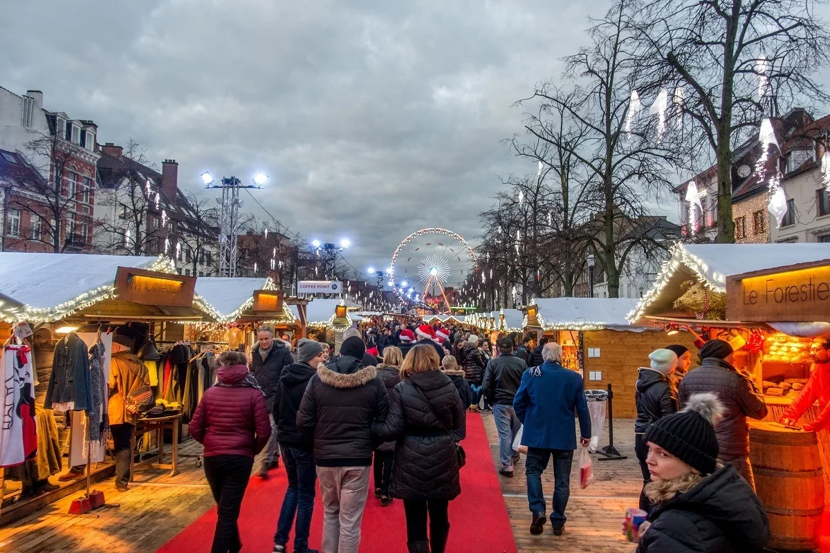 People walking through rows of Christmas market vendors