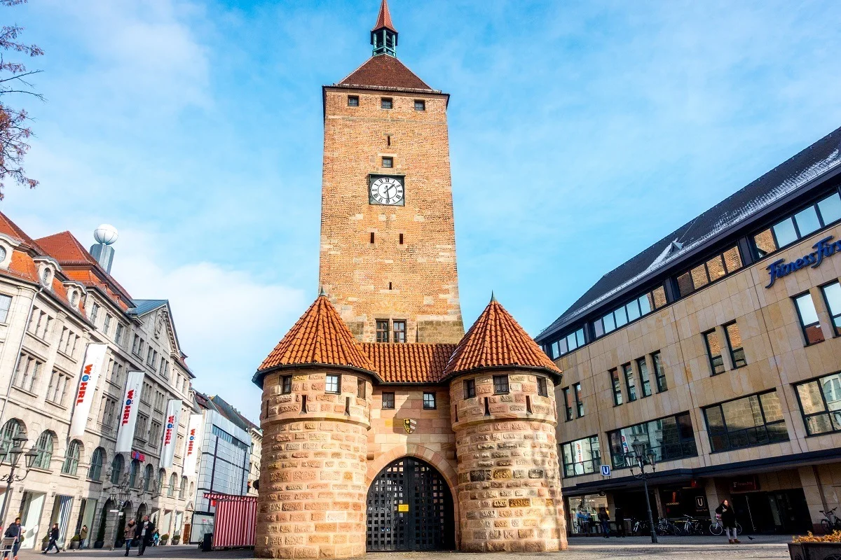Tall brick tower with the arched city gate immediately in front of it