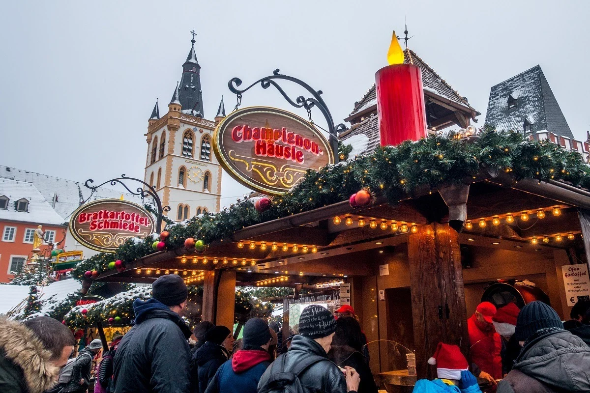 People at food stalls covered with garland and lights 