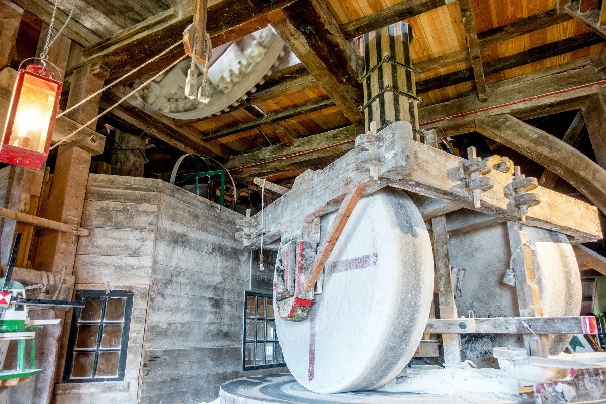 Large wheels grinding chalk into powder inside a windmill