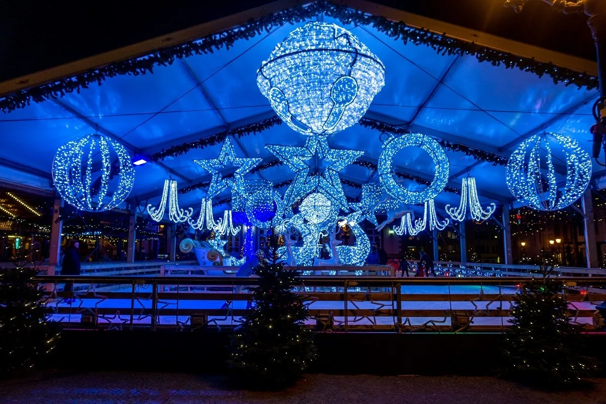 Ice-skating rink trimmed with blue Christmas lights at night