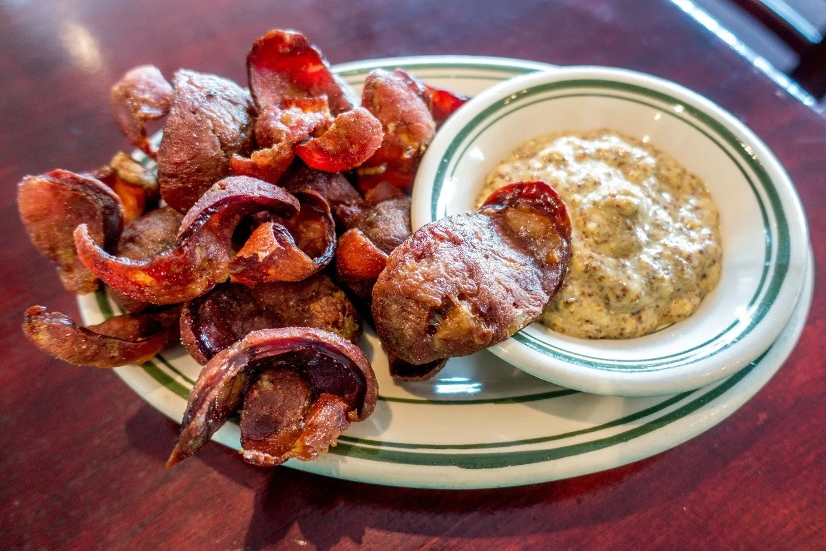 Fried andouille chips with a side of mustard. 