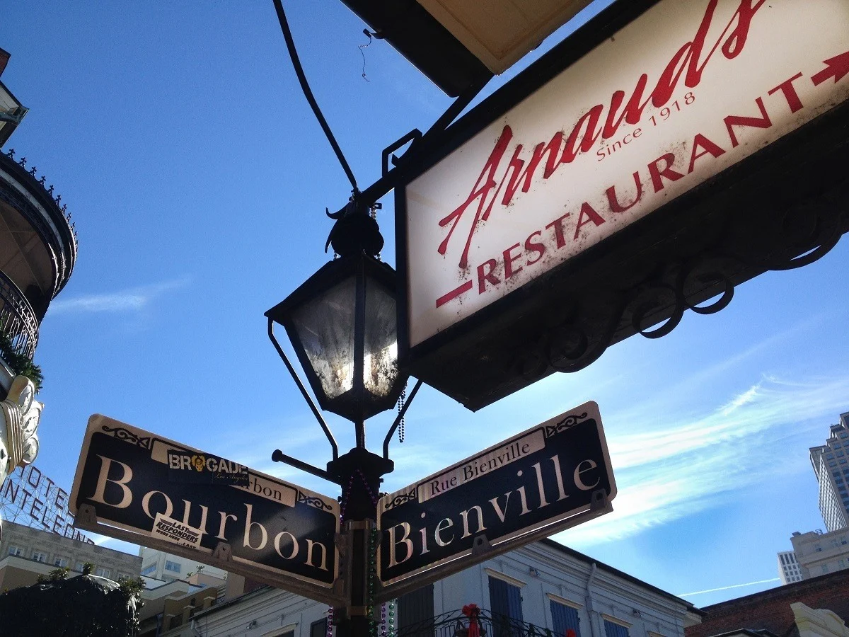 Sign for Arnaud's Restaurant beside street sign at Bourbon and Bienville