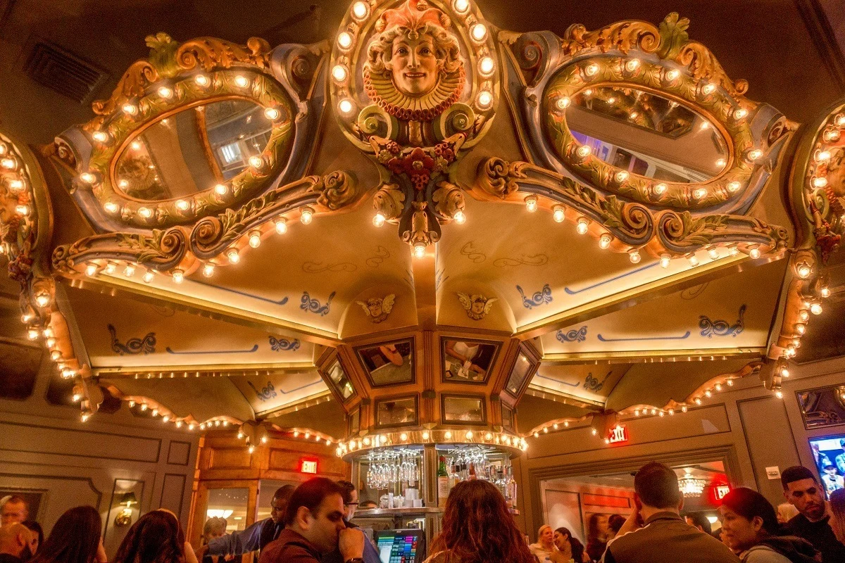 People sitting at the circular Carousel Bar at night