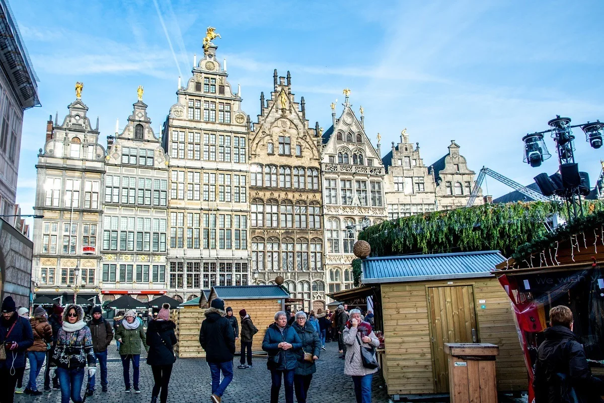 People visiting Christmas market stalls in a city square