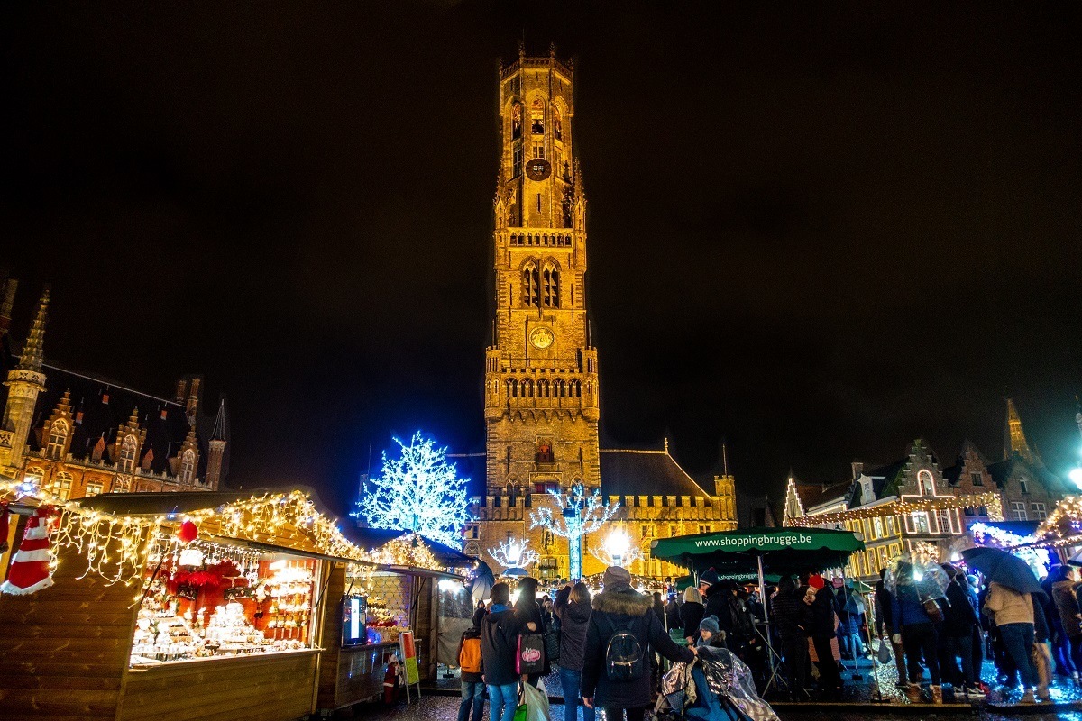 Bell tower soars over people shopping at market stalls