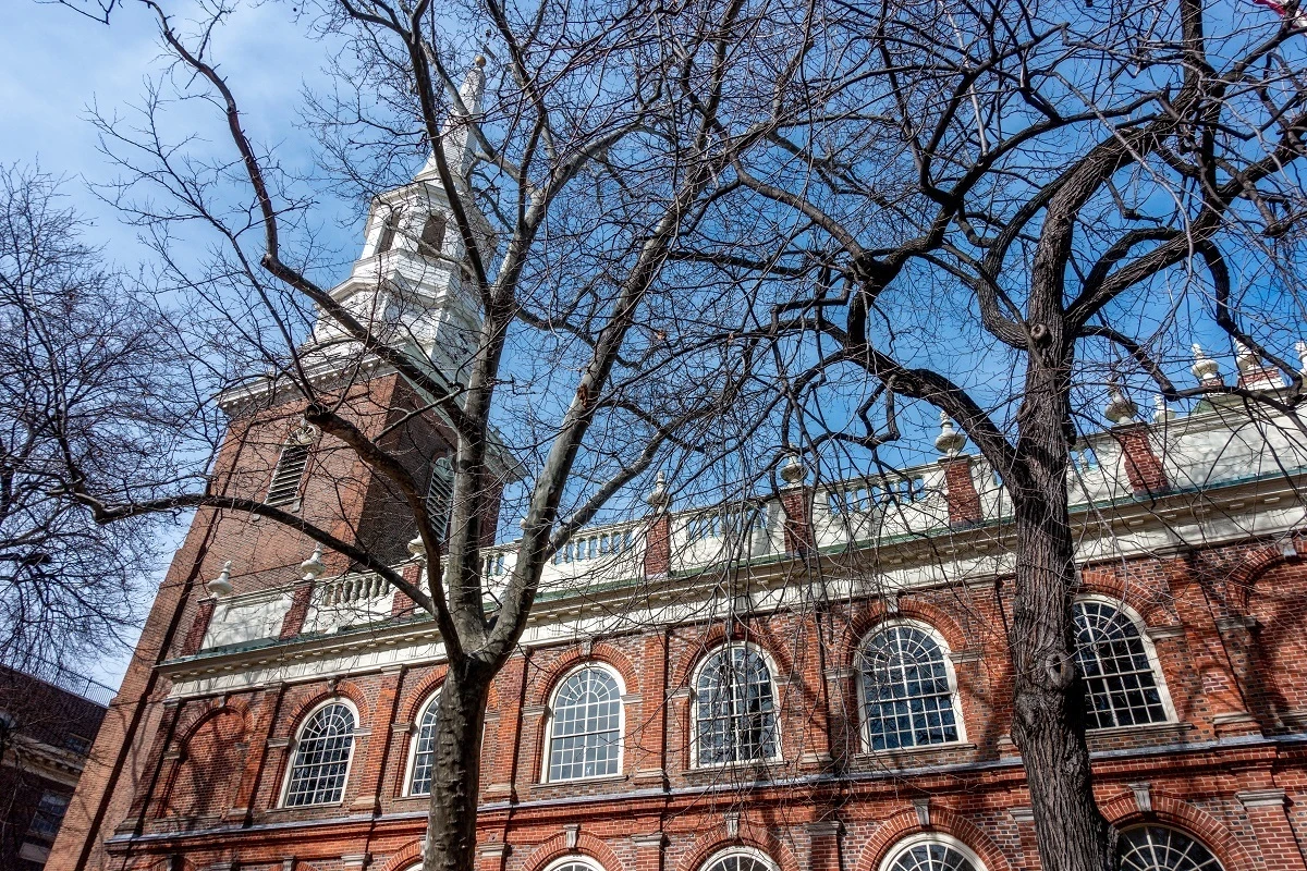 Exterior of a brick church with a white steeple