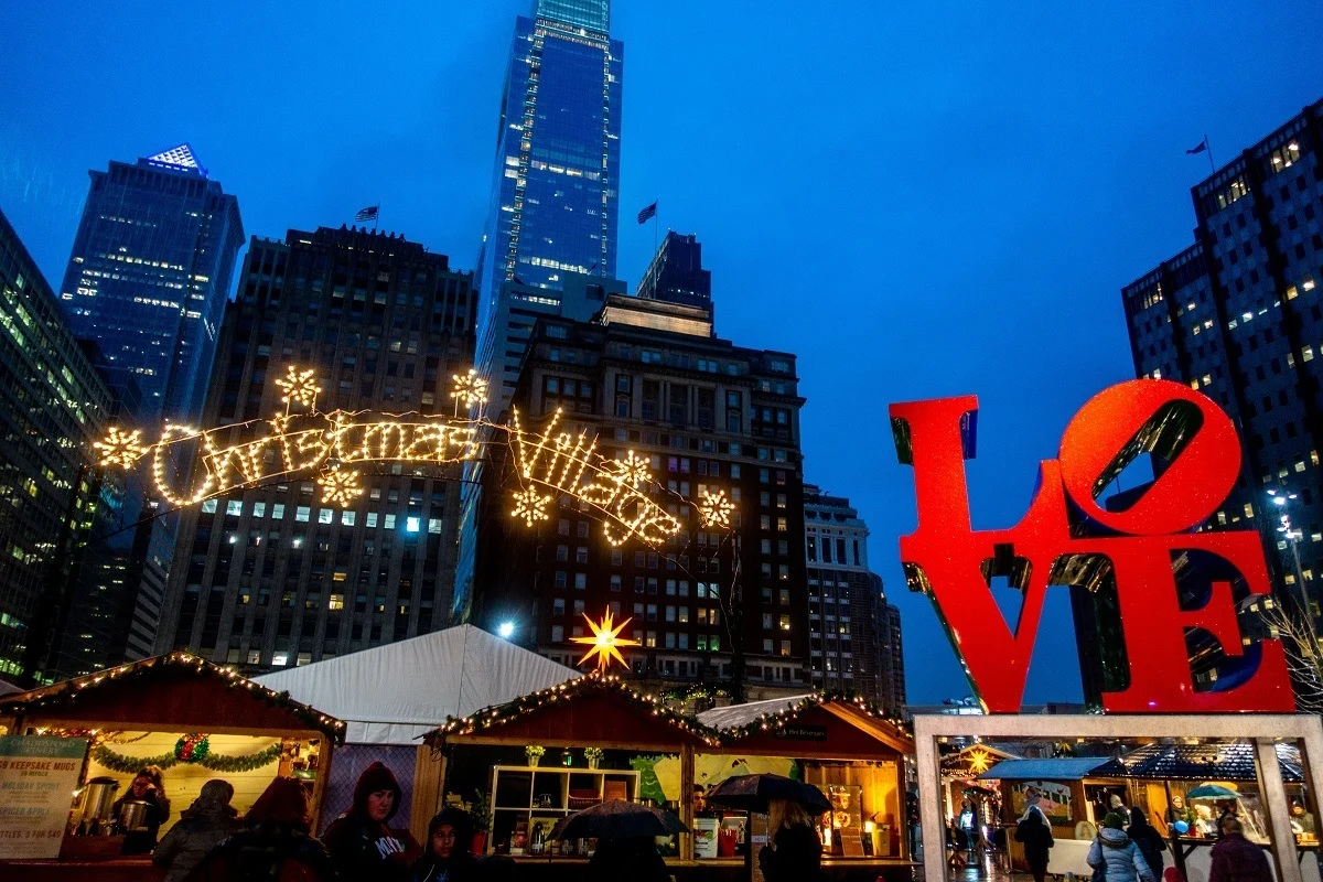 Christmas market stalls in LOVE Park with red LOVE statue