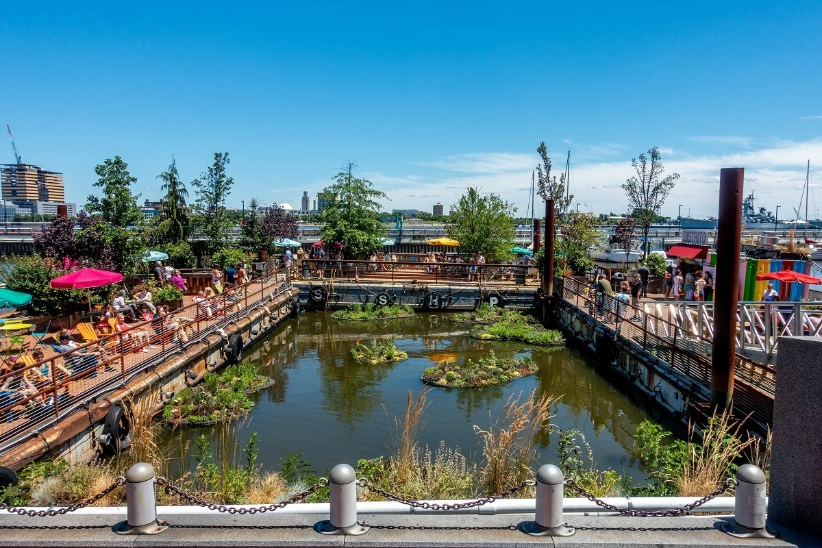 People sitting under colorful umbrellas around a floating garden