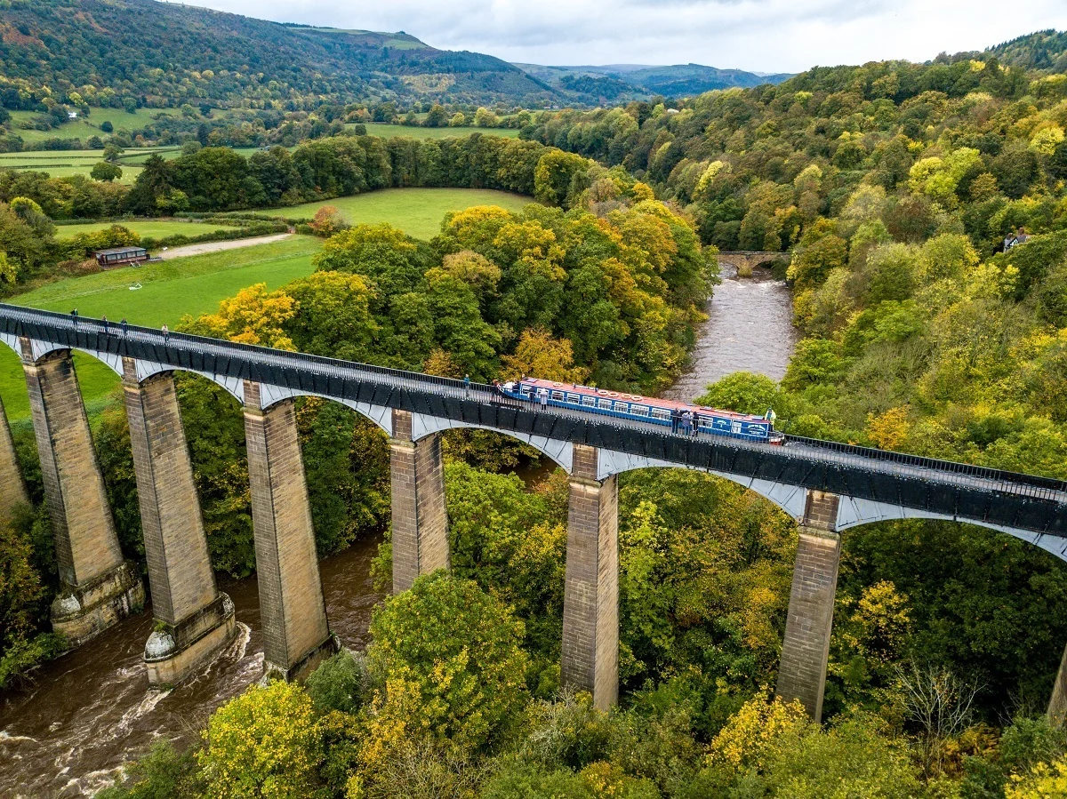 Aerial photo of a boat in Pontcysyllte Aqueduct which crosses the river below