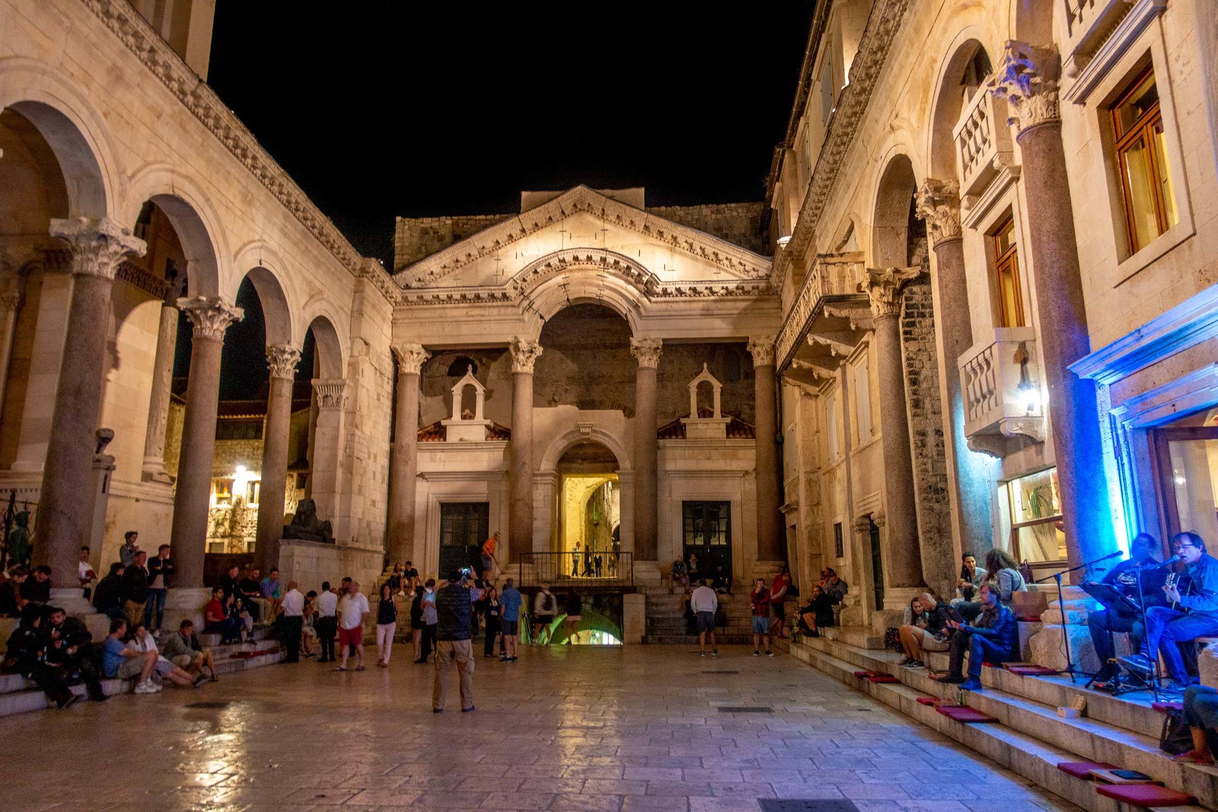 Marble peristyle courtyard of Diocletian's Palace filled with people at night