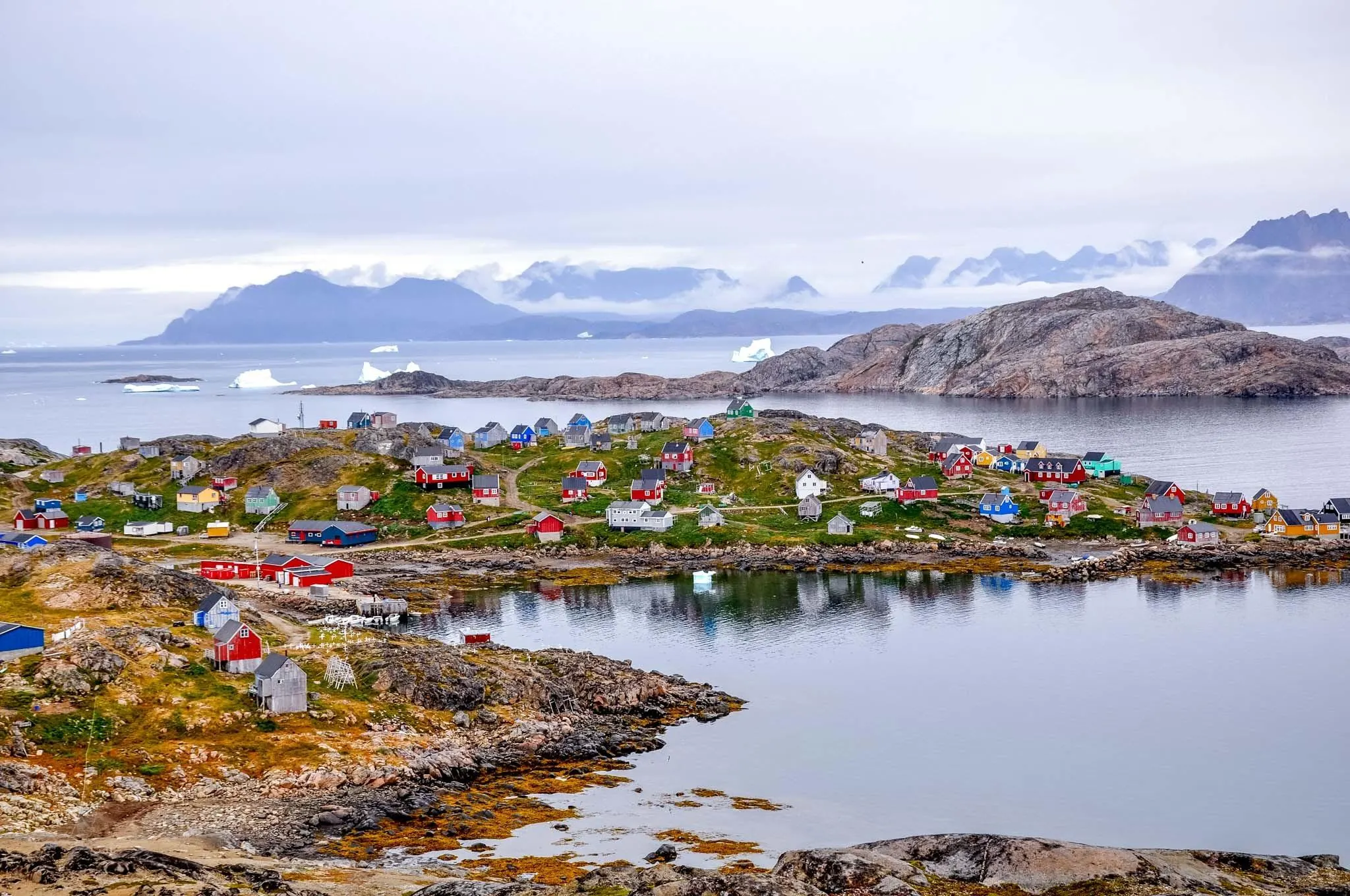 Harbor and colorful homes along the coastline of Greenland.