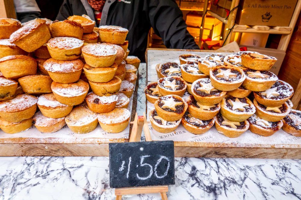 Stacks of small mince pies for sale at the Christmas market in Bath UK