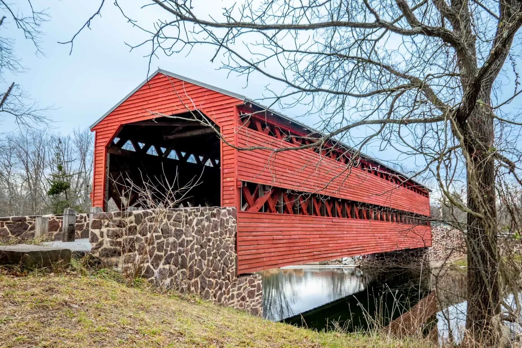 Red covered bridge over a creek.