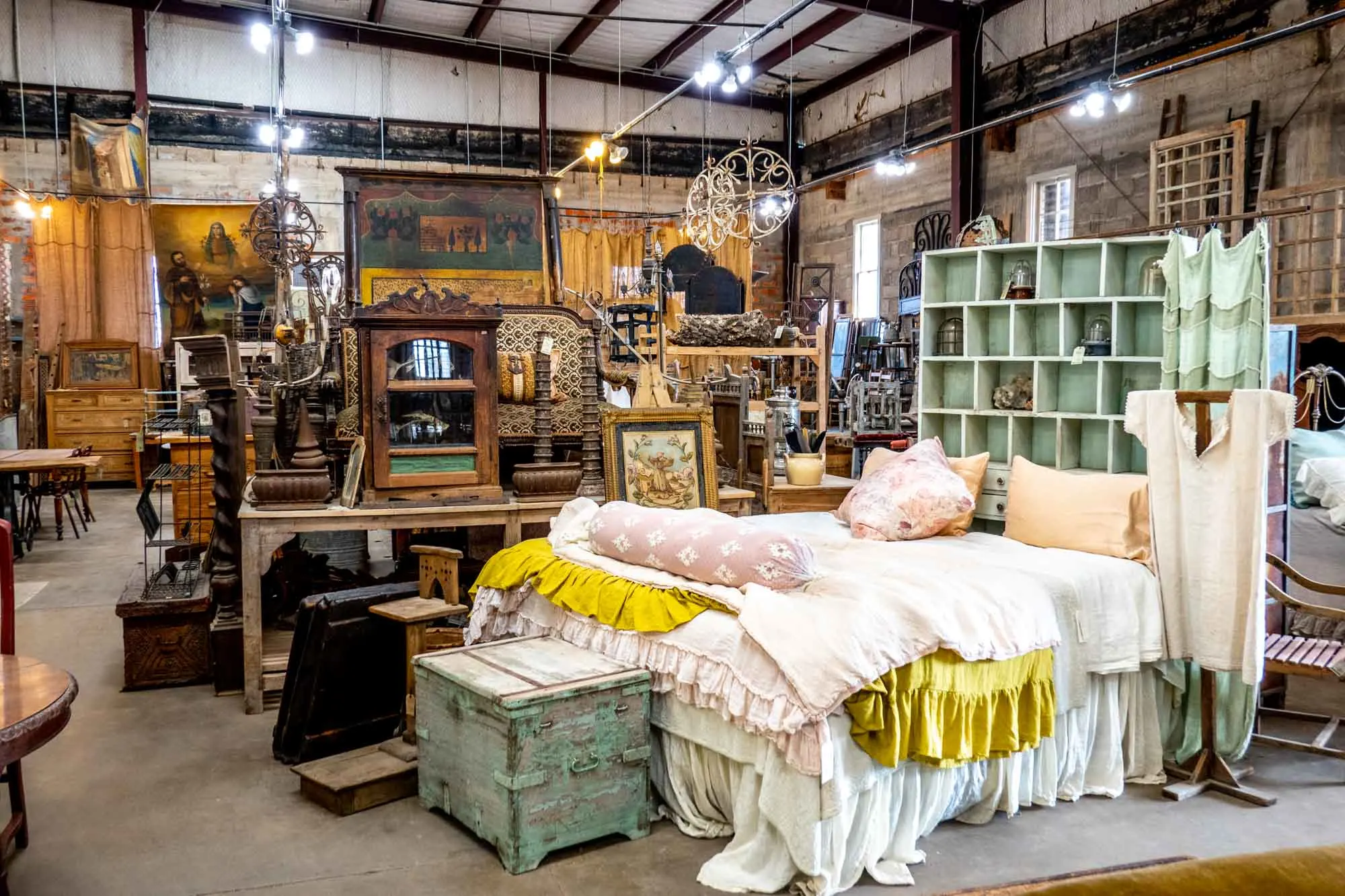Bed and an assortment of antiques in a showroom.