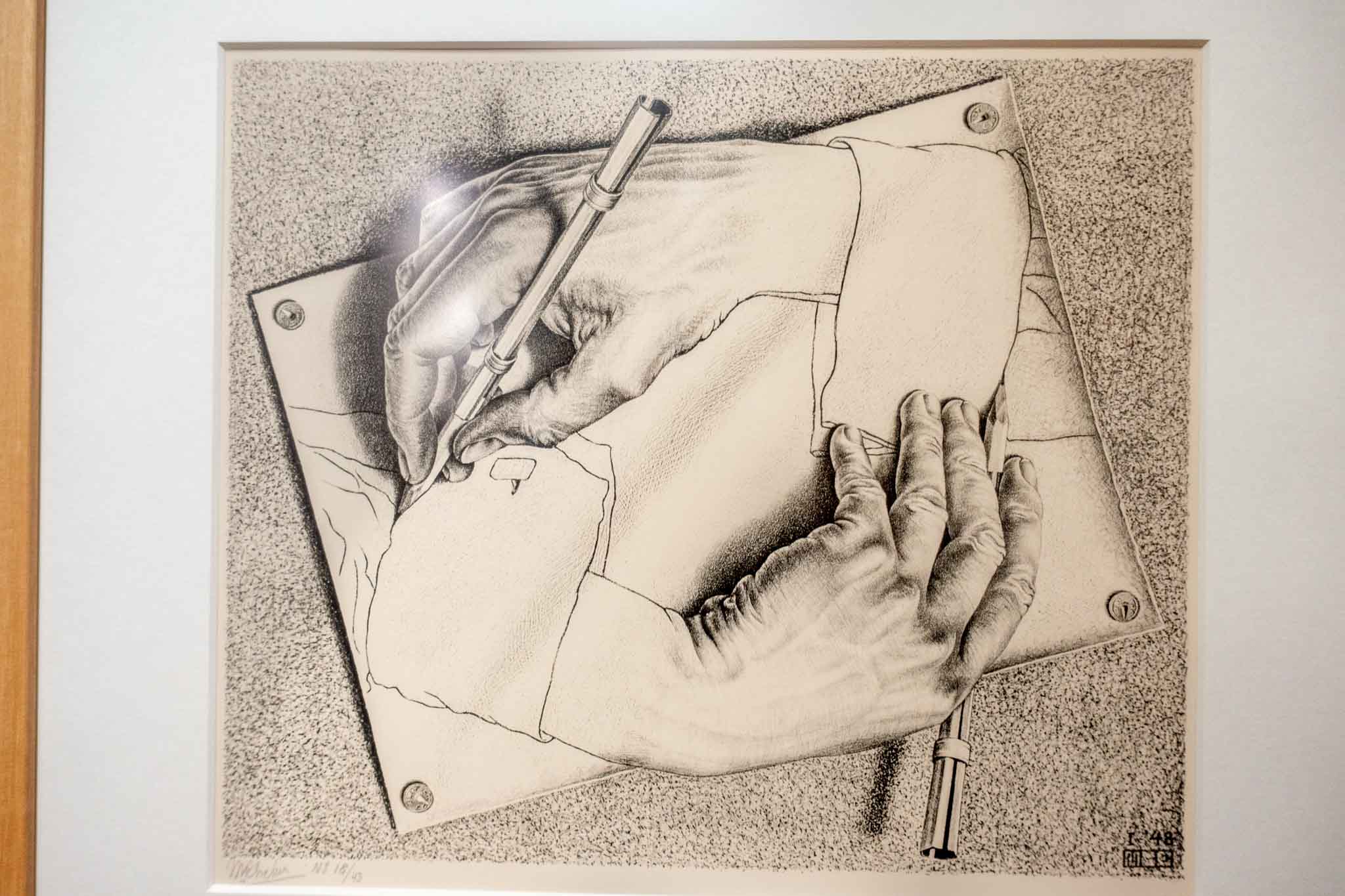 Artwork of two hands drawing each other.