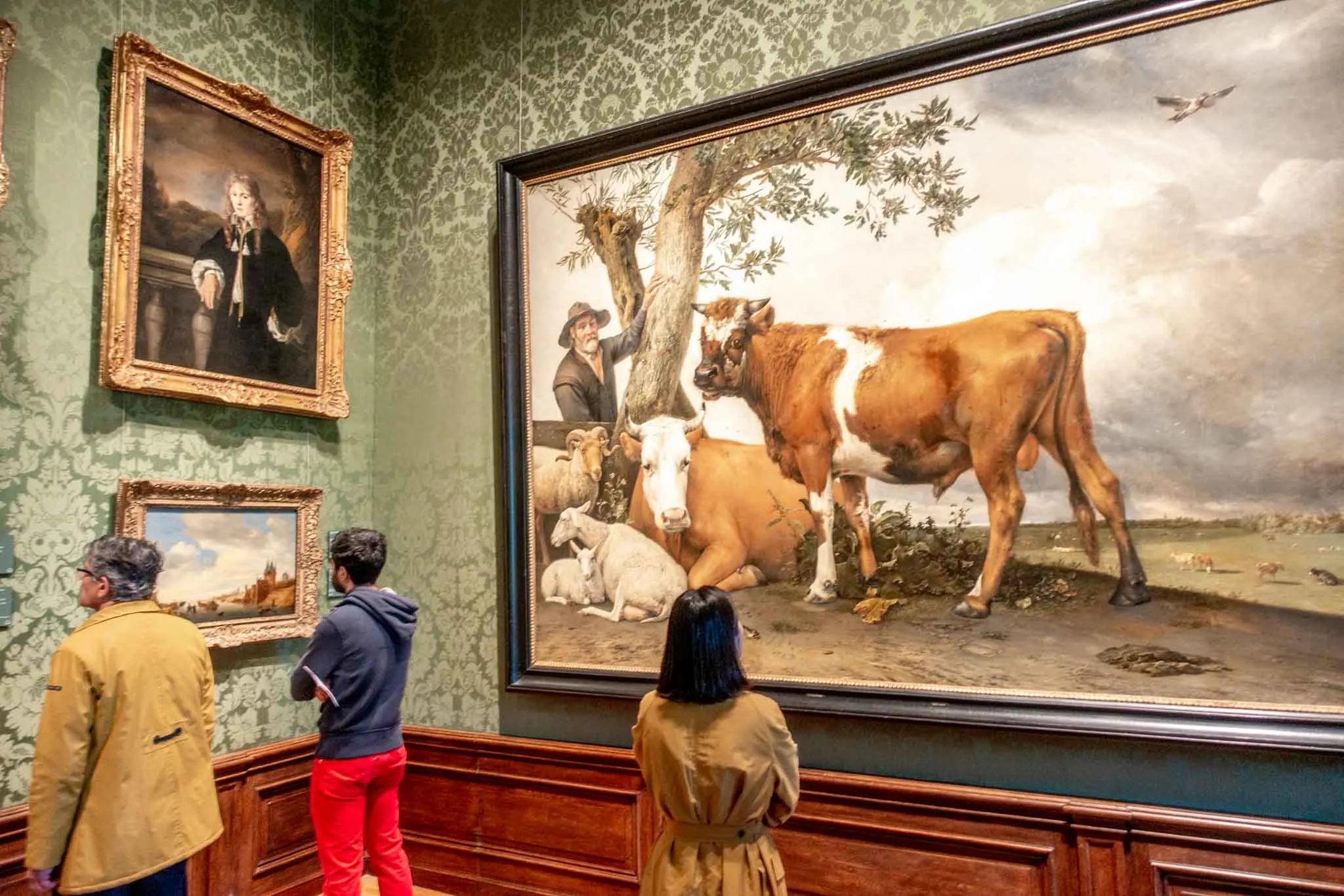 Visitors looking at paintings in a museum.