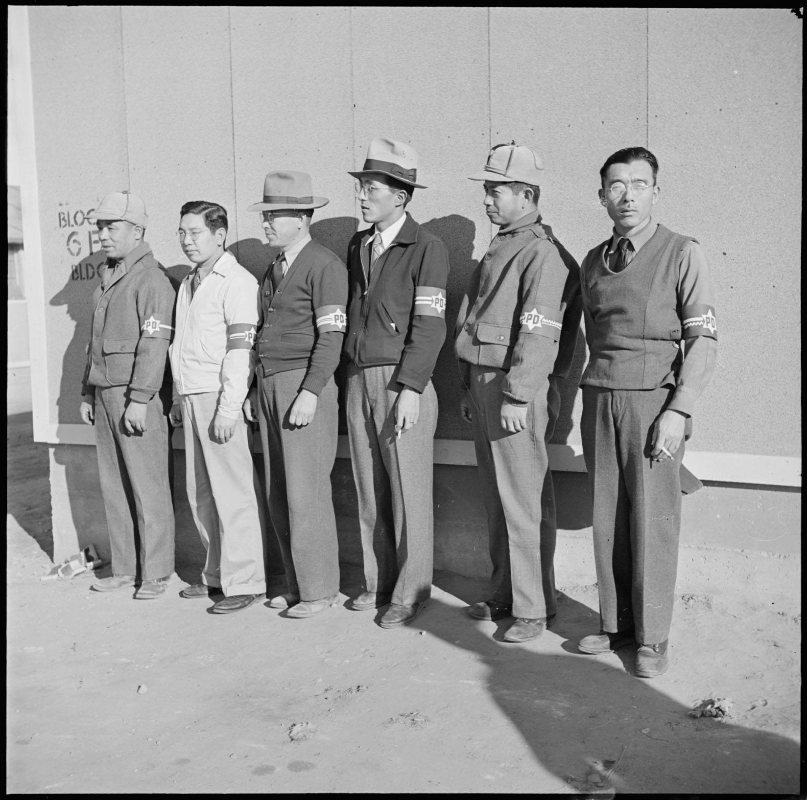 Japanese interment camp detainees wearing identification arm bands
