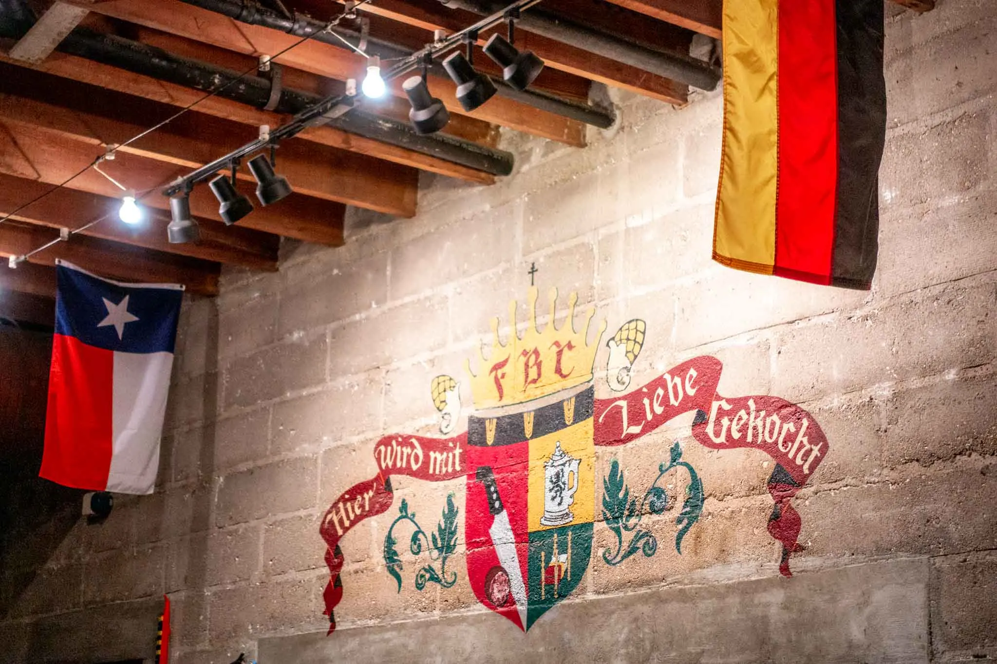German crest on the wall with German and Texas flags