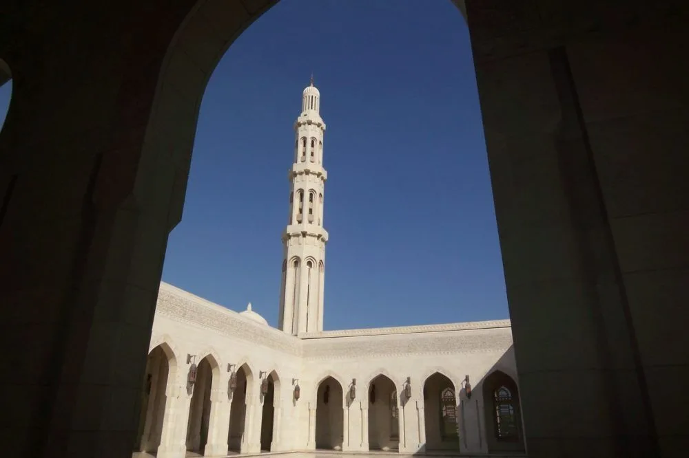 White mosque seen through an archway