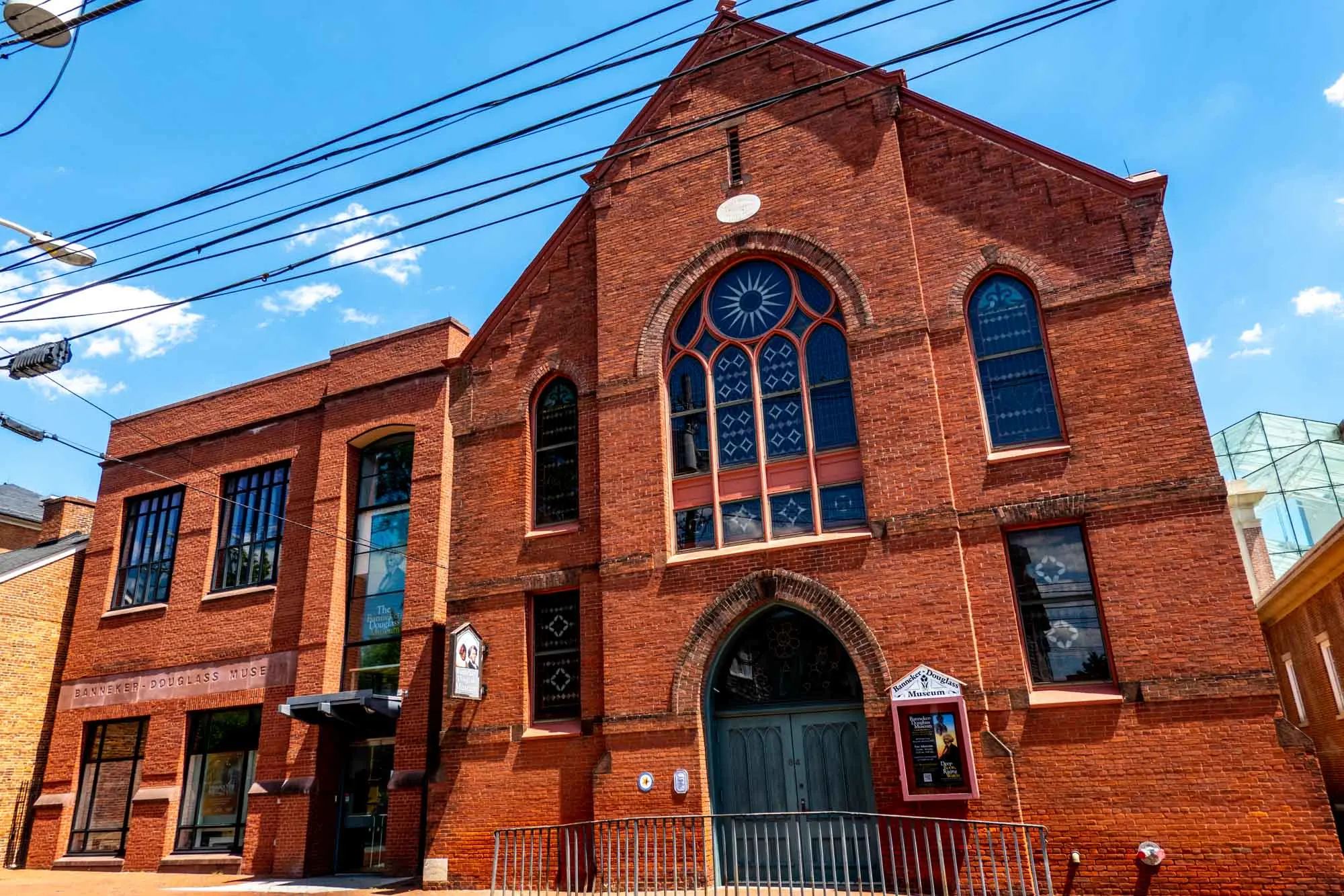 Exterior of a red brick church with stained glass windows