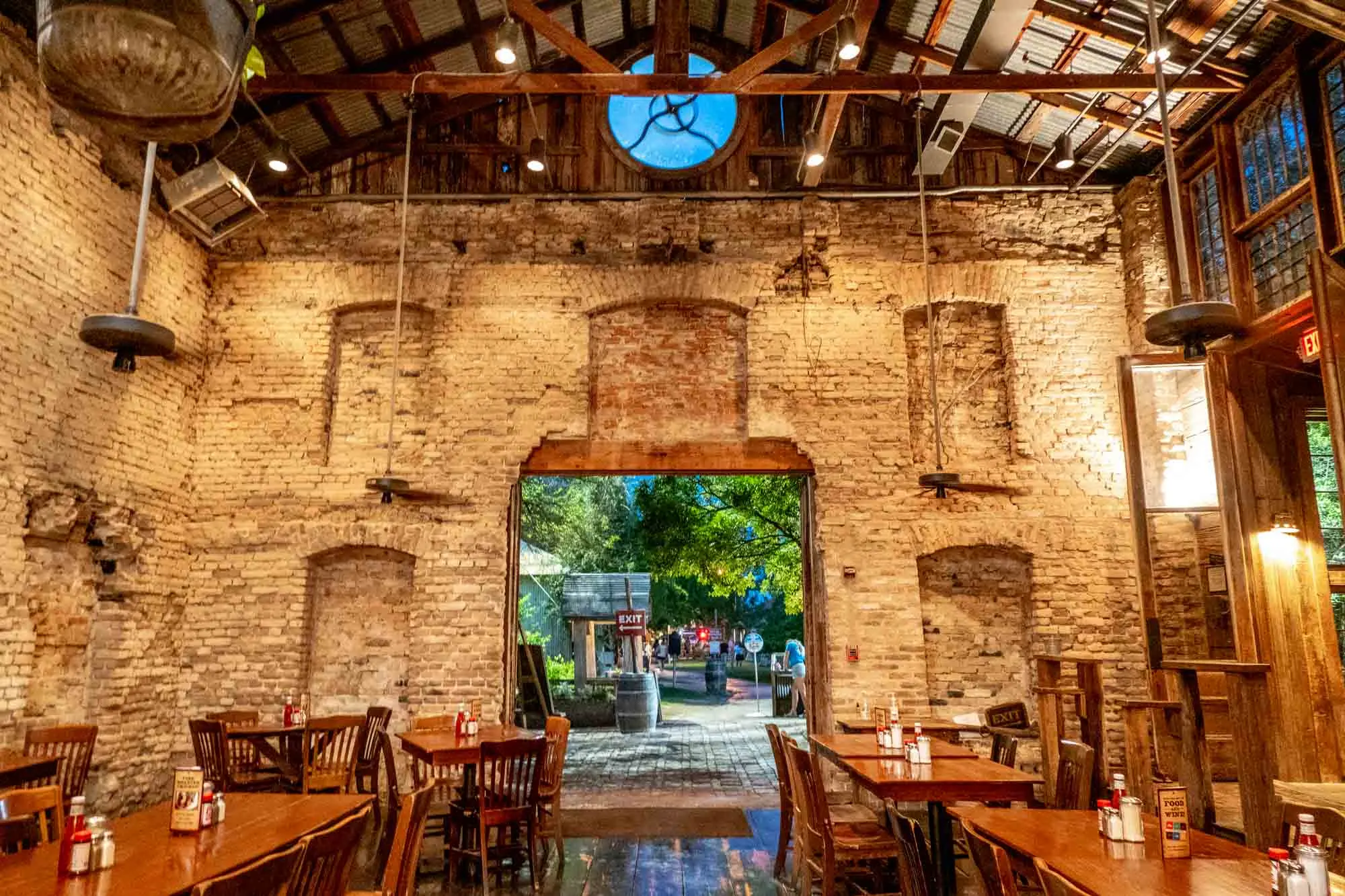 Inside a room with white brick walls filled with restaurant tables and chairs