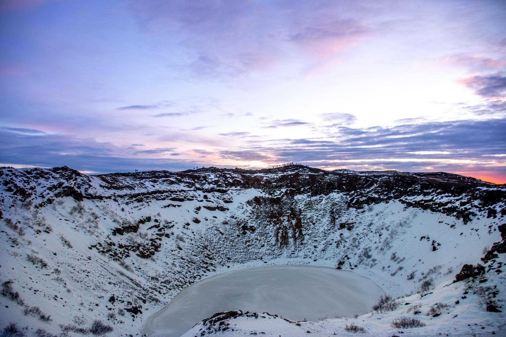 Crater and lake in the snow with purple sunset