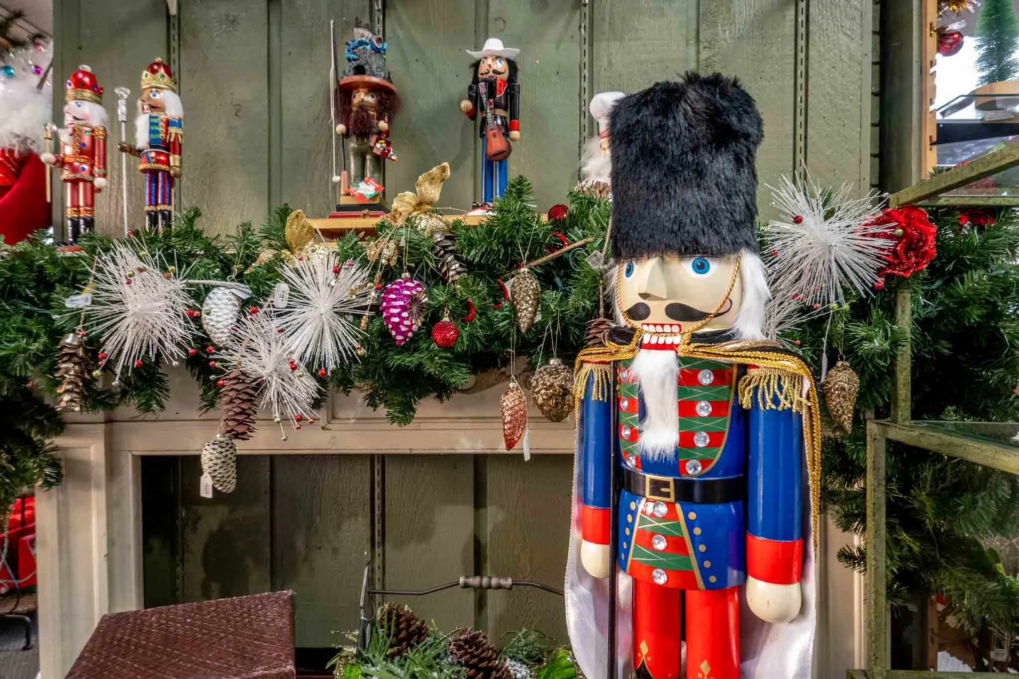 3-foot-tall Nutcracker in front of a mantel lined with small Nutcrackers