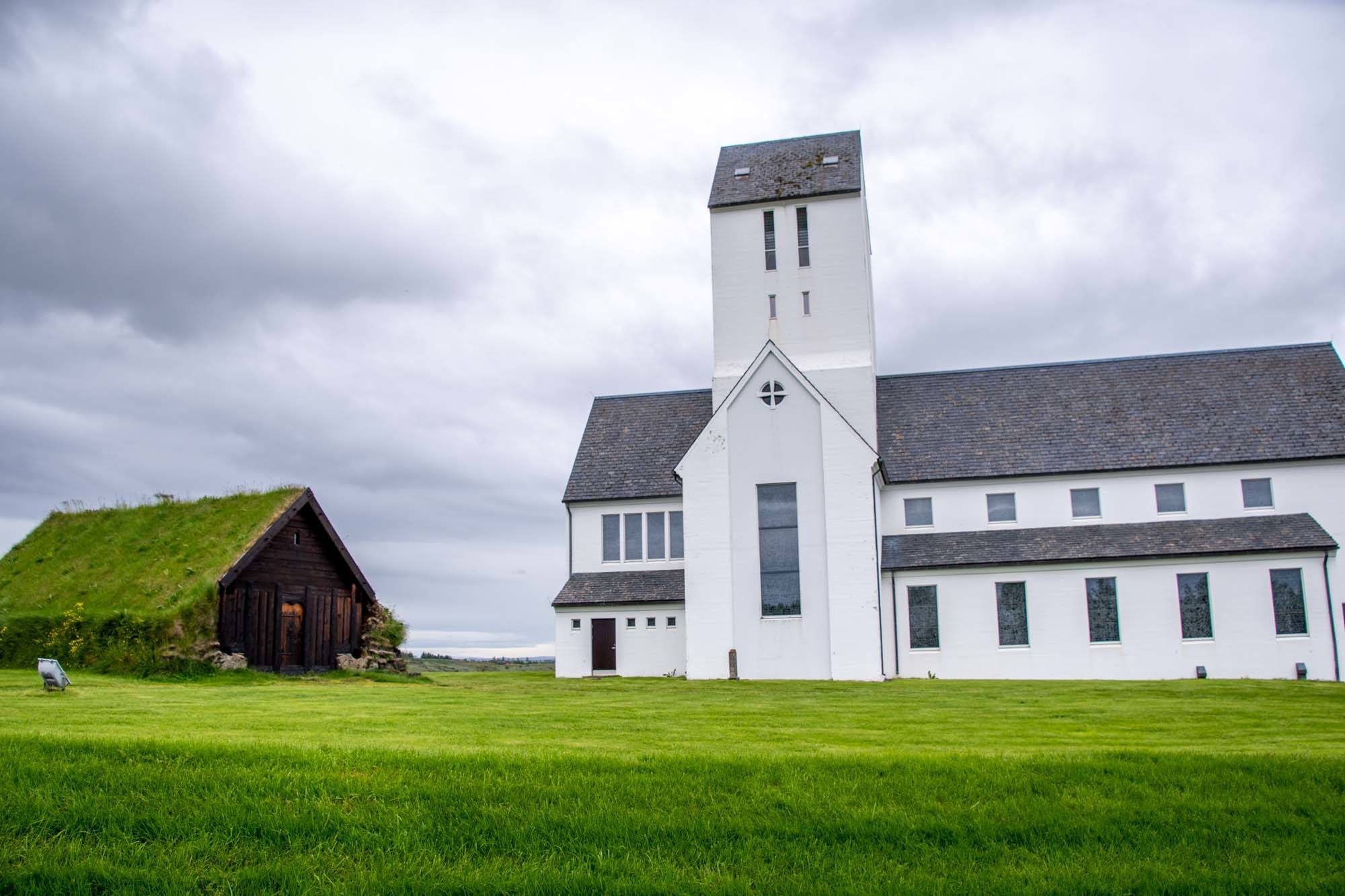Old turf church next to modern white cathedral