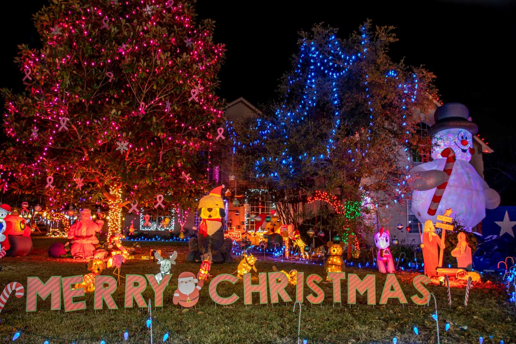 Christmas light display including an inflatable snowman and other characters plus a Merry Christmas sign 