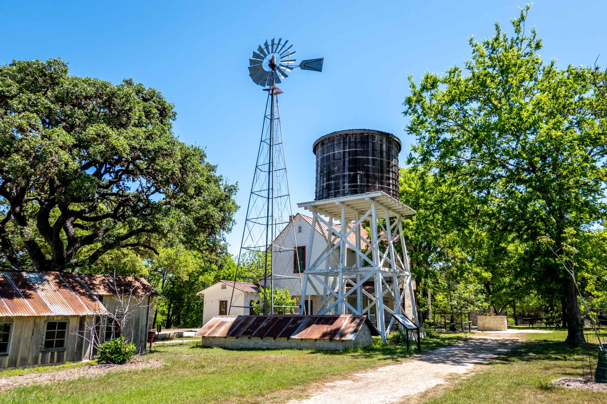Windmill, wooden water tower, and old buildings on a sunny day