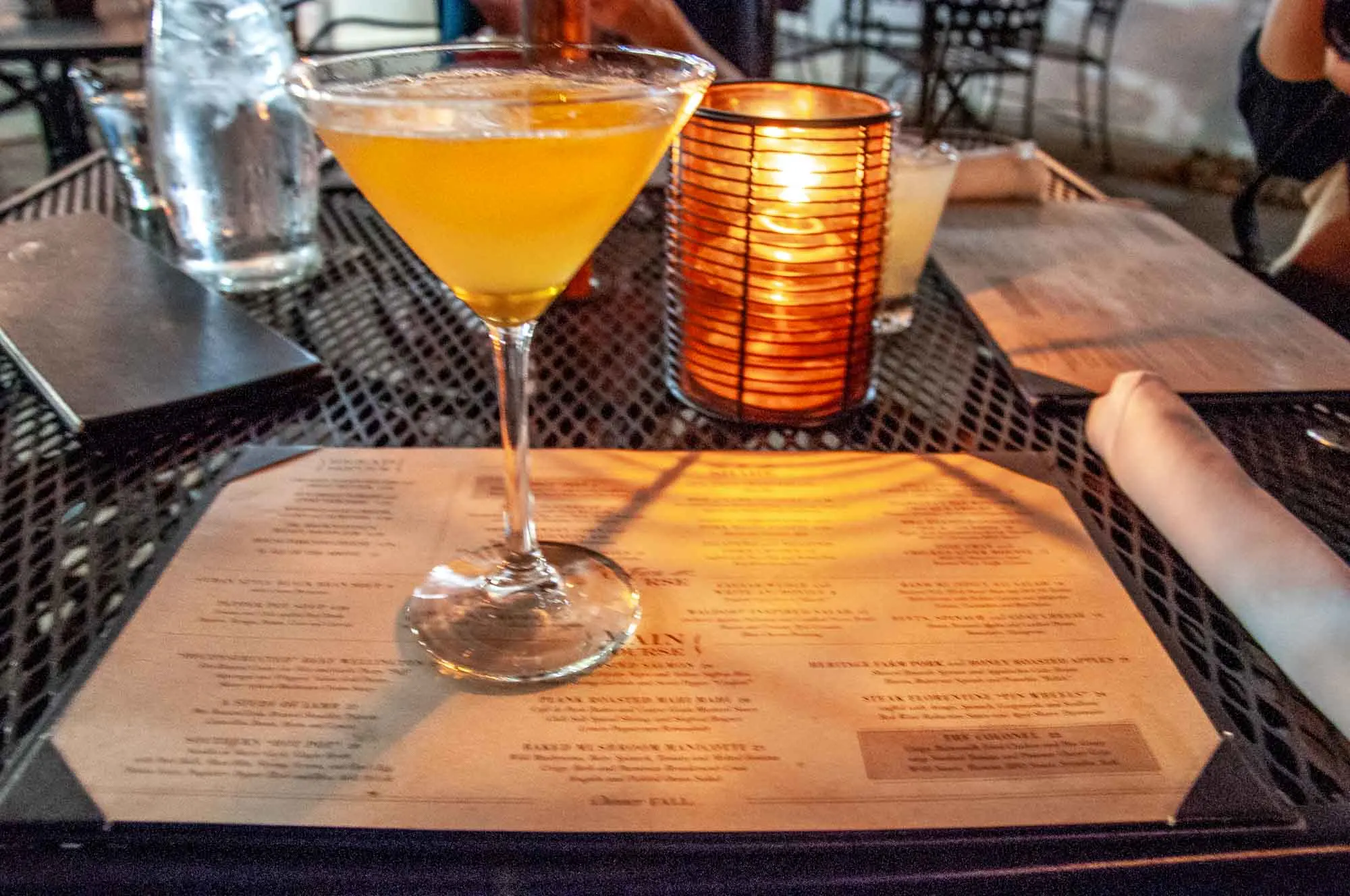 Martini glass and candle on an outdoor restaurant table