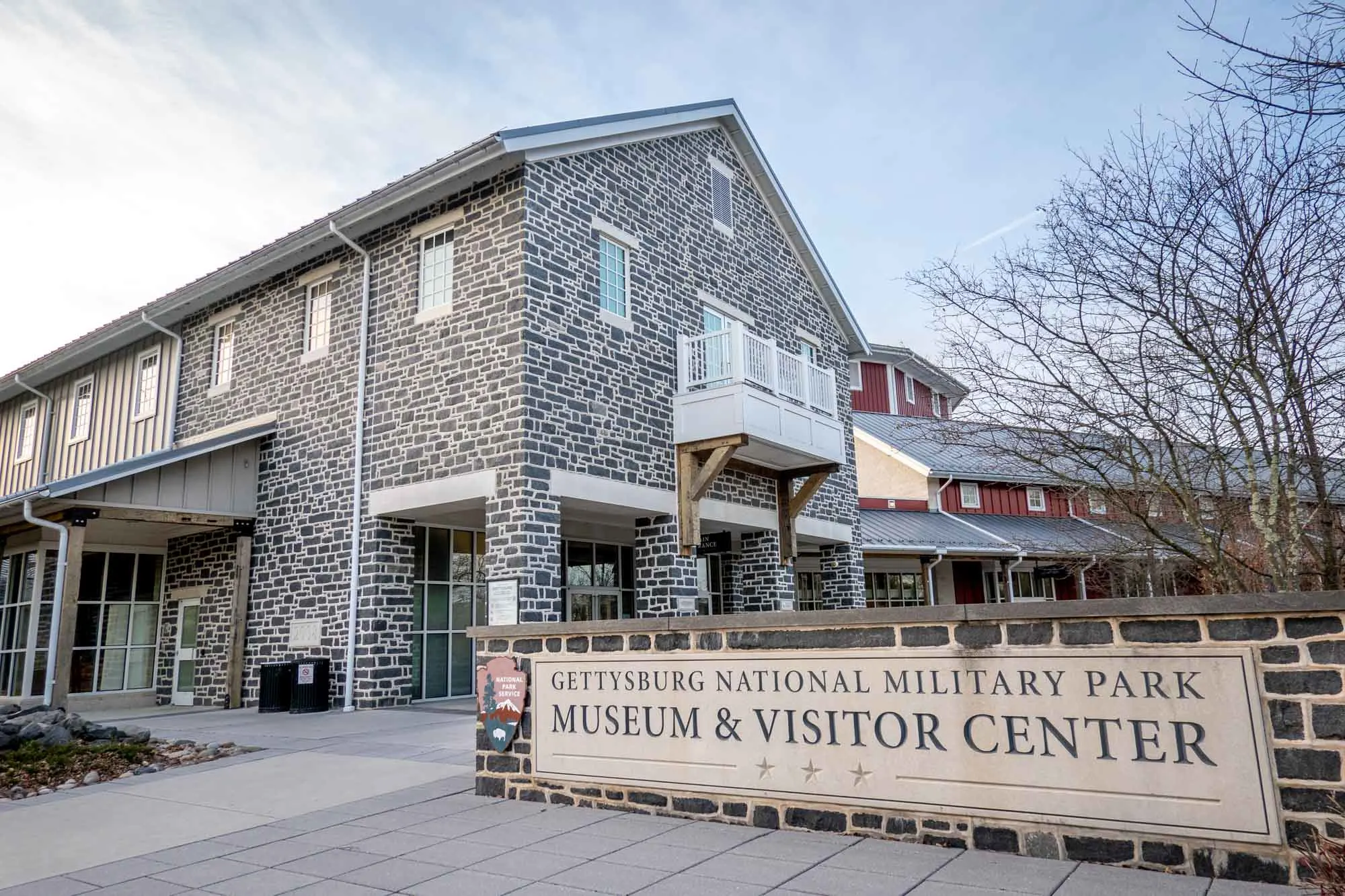 Stone building beside a sign for "Gettysburg National Military Park Museum & Visitor Center"