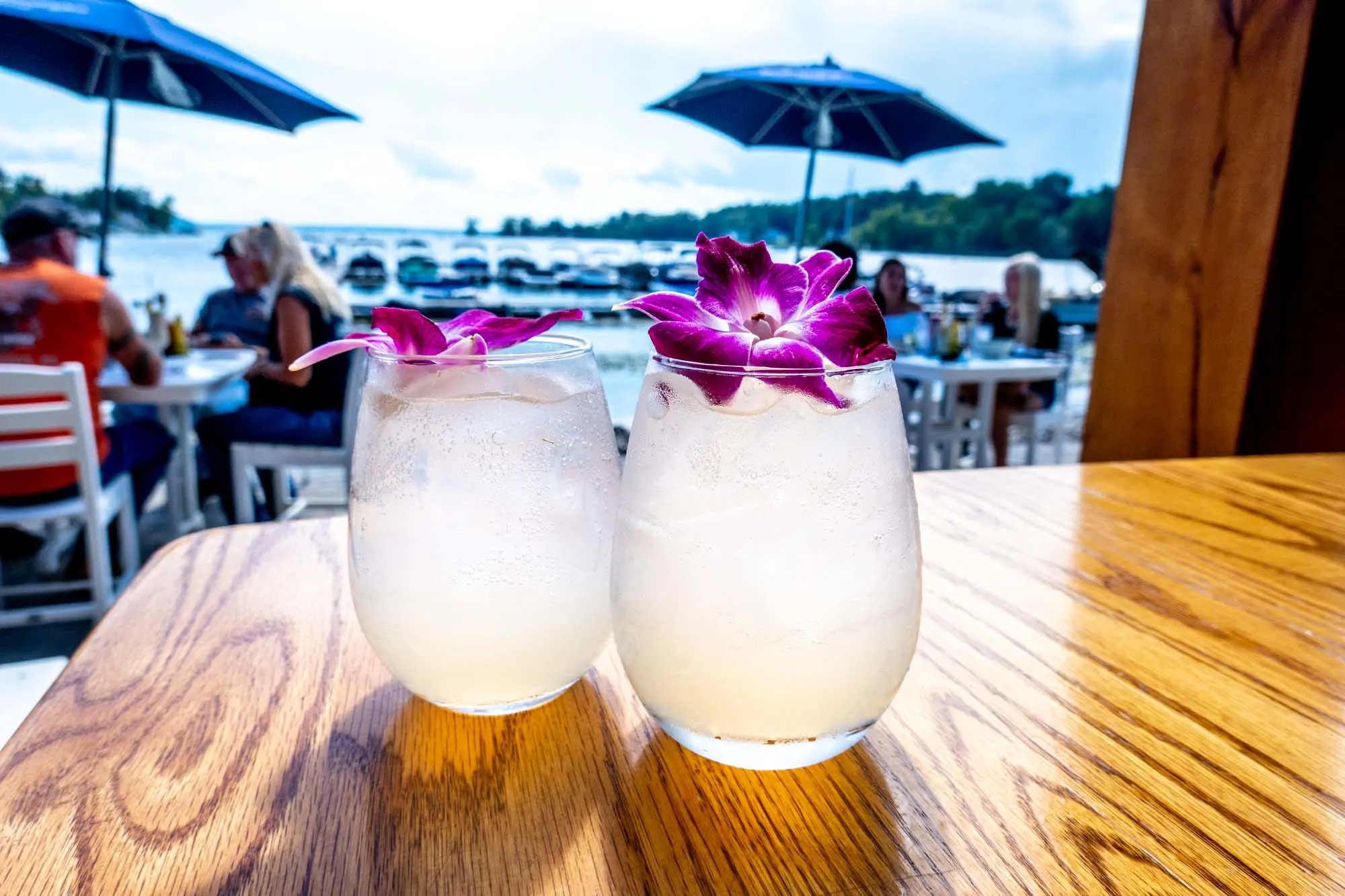 Two cocktails on a table with a lakeside view