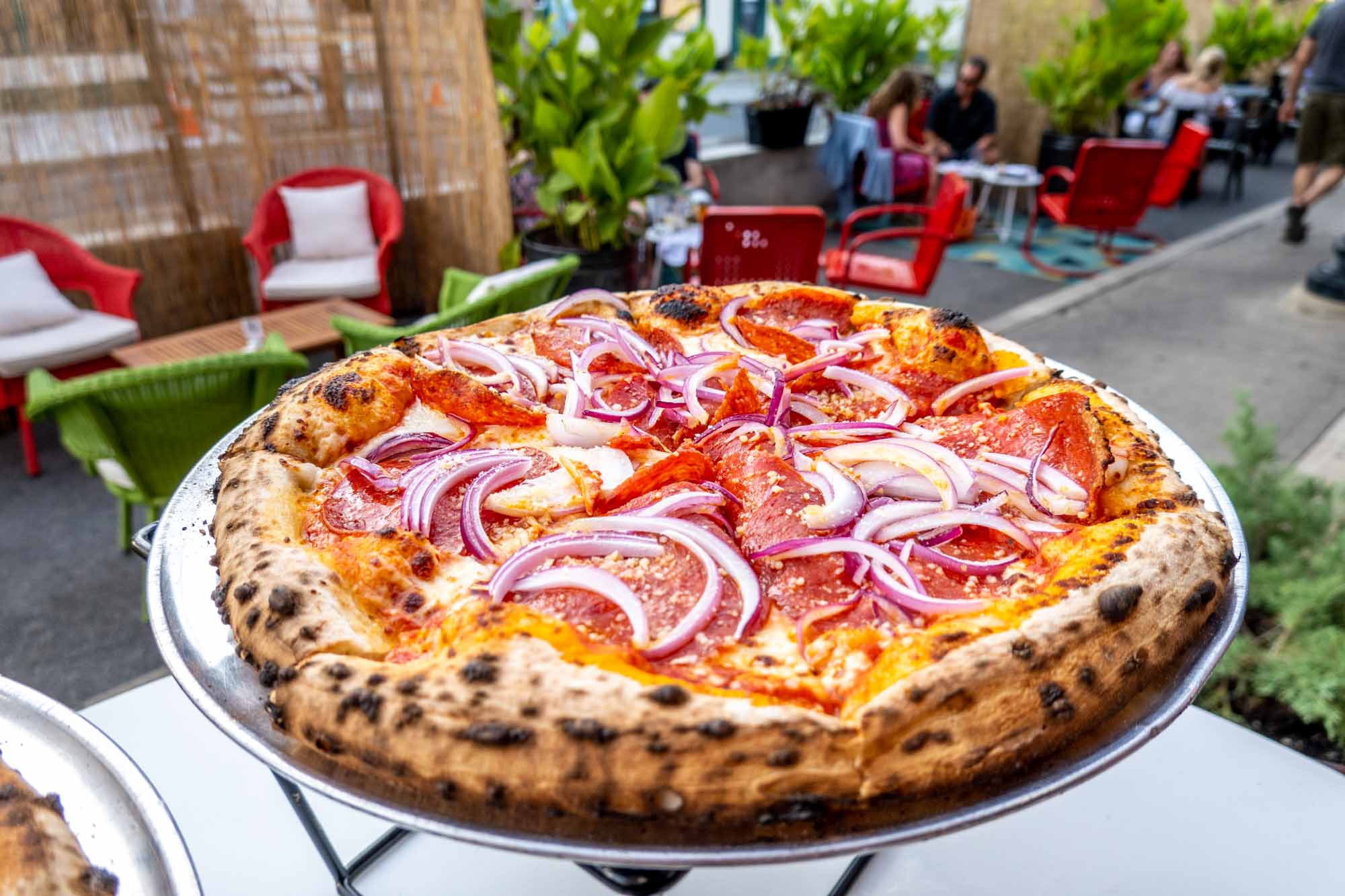 Pepperoni and onion pizza on an outdoor table at a restaurant
