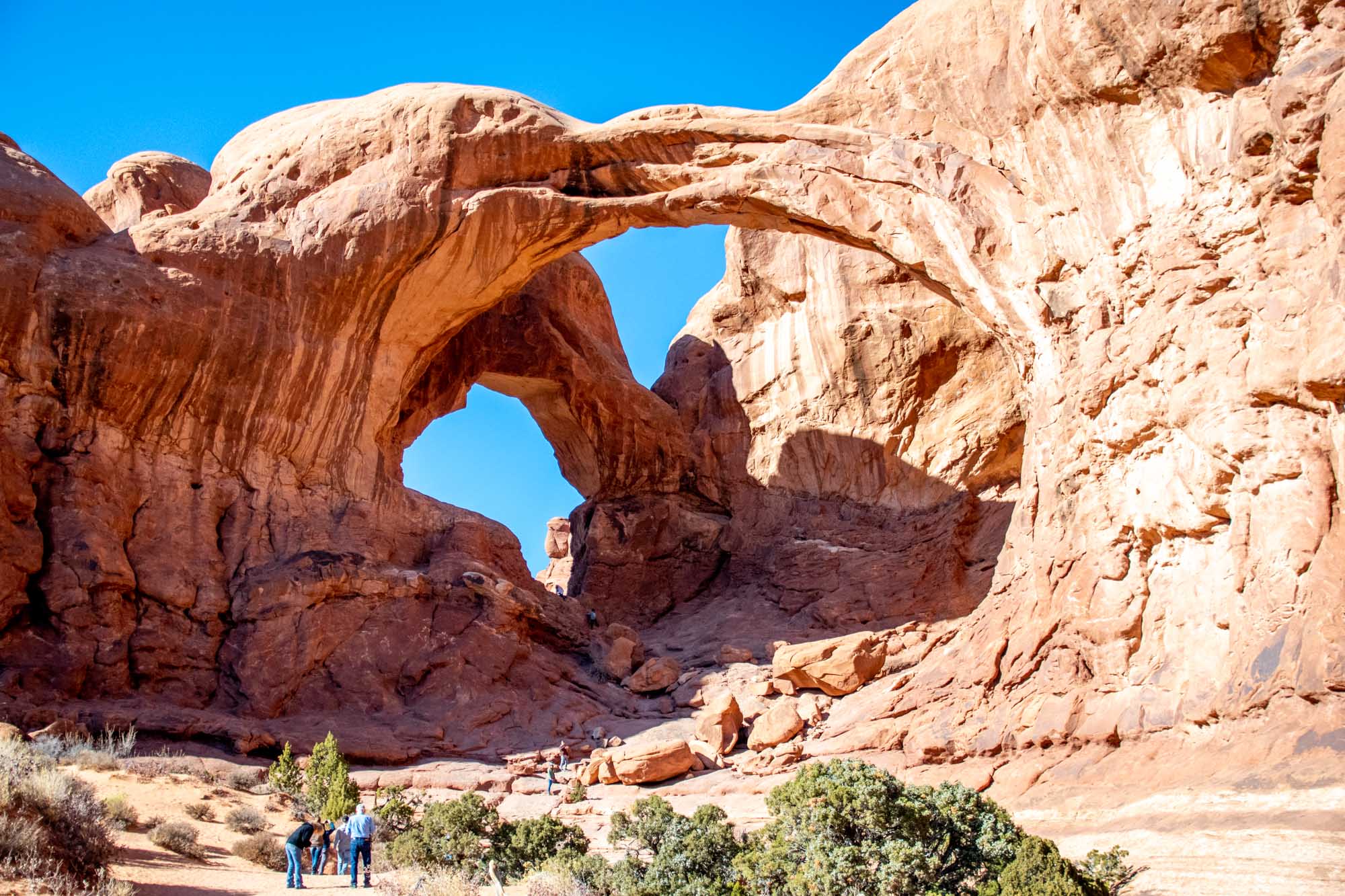 People at the Double Arch rock formation