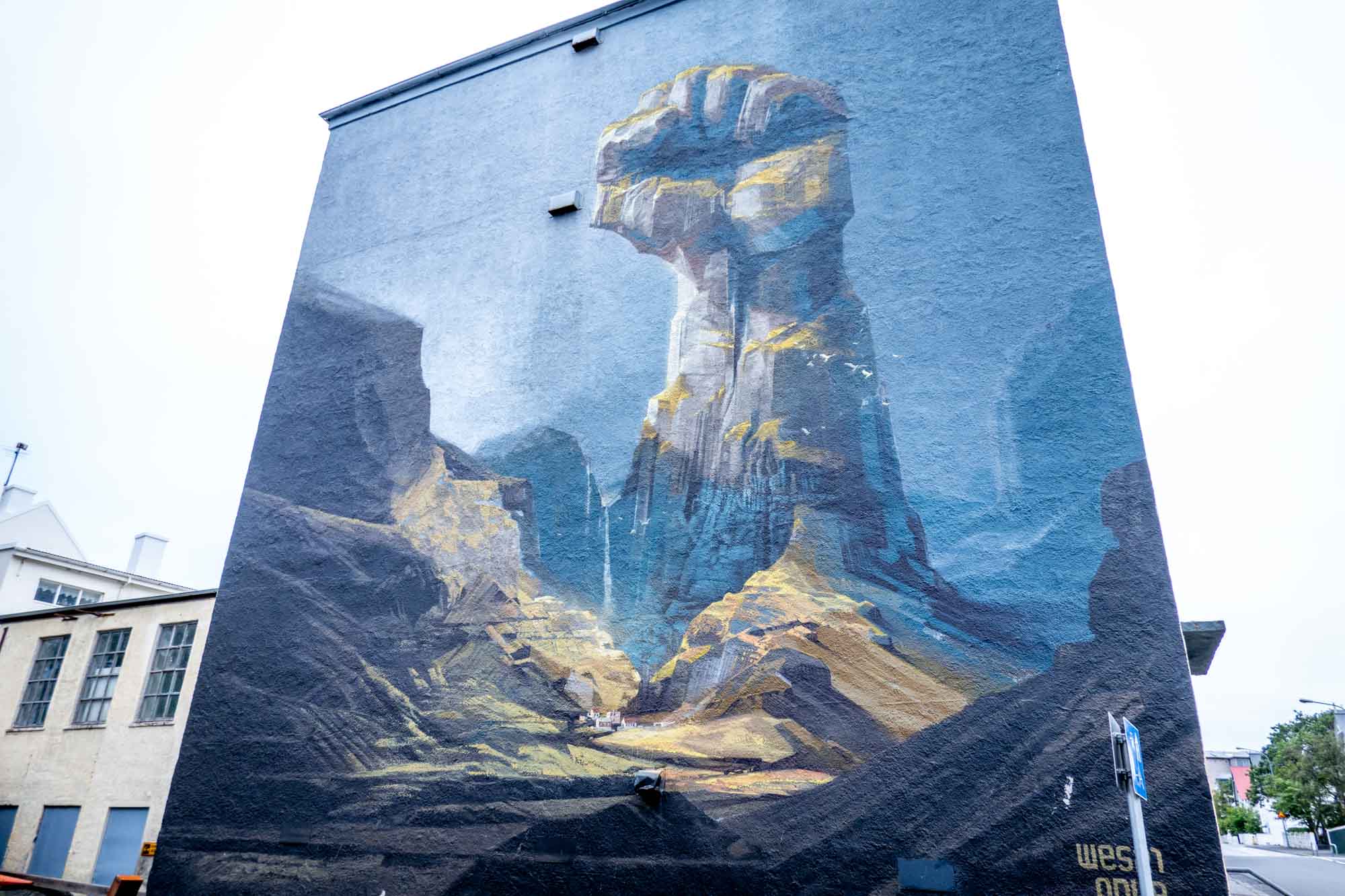 Mural on building of a rock mountain in the shape of a raised fist