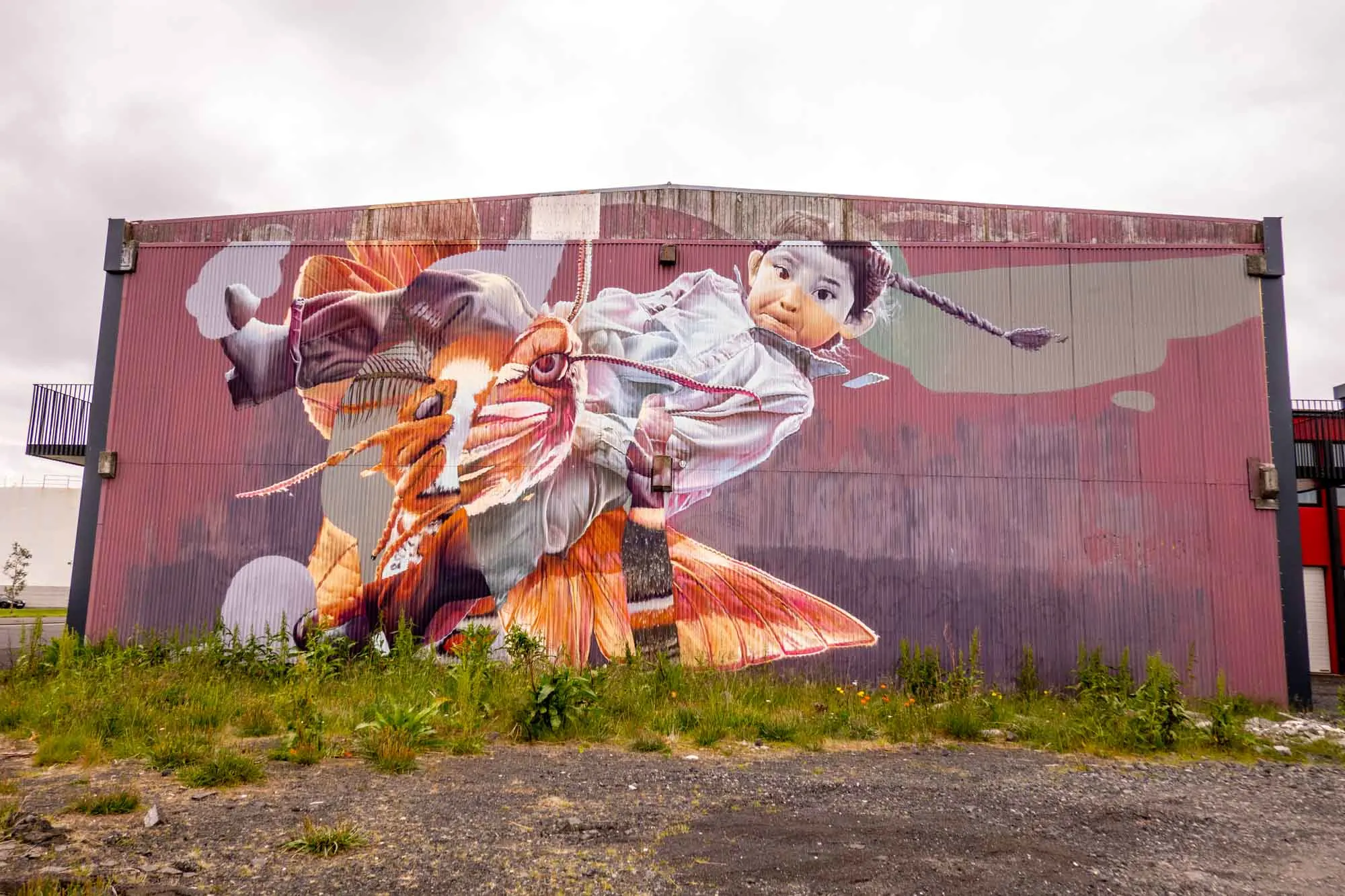 Building mural of young girl riding a moth