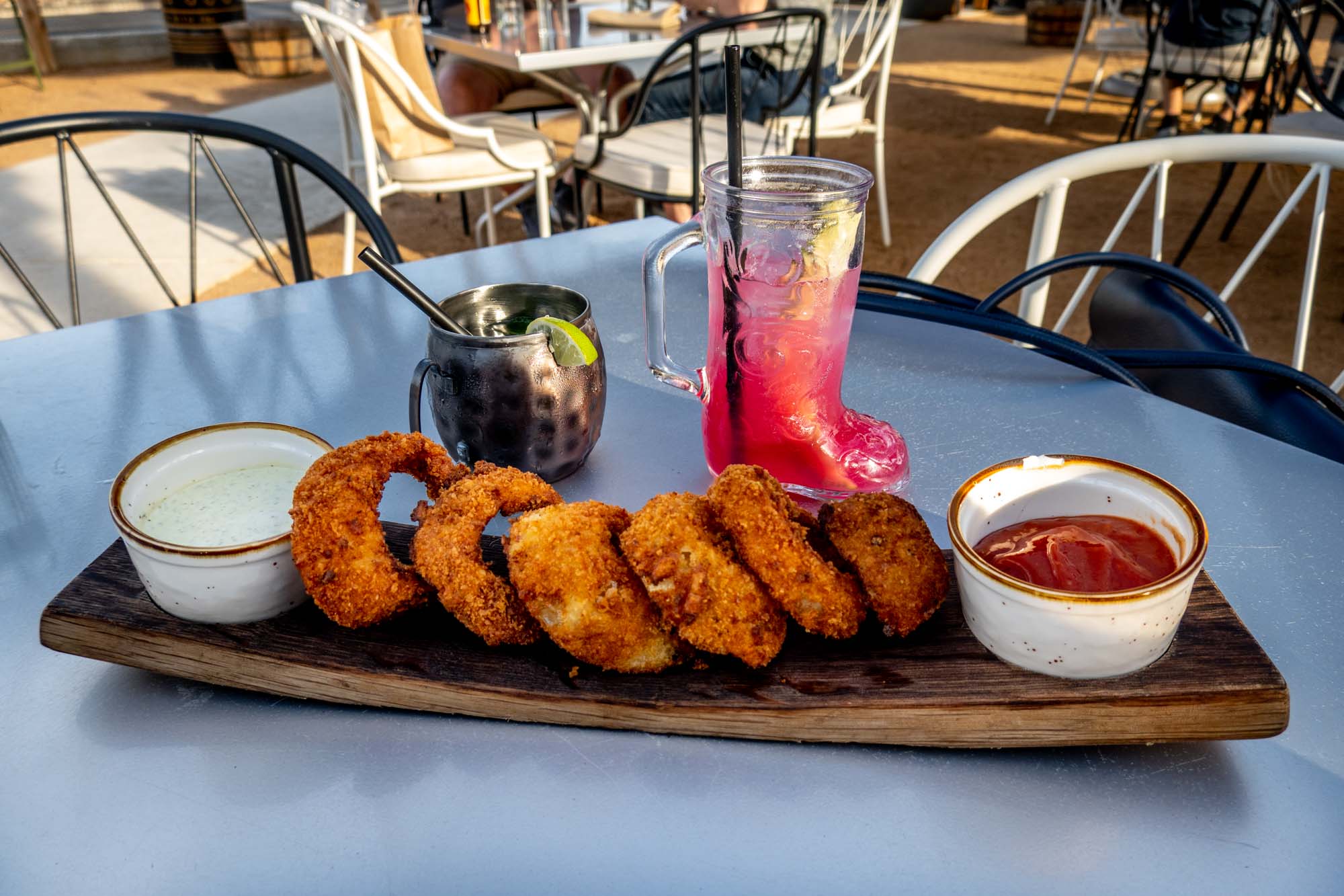 Onion rings and two cocktails on an outdoor table at a Fredericksburg restaurant