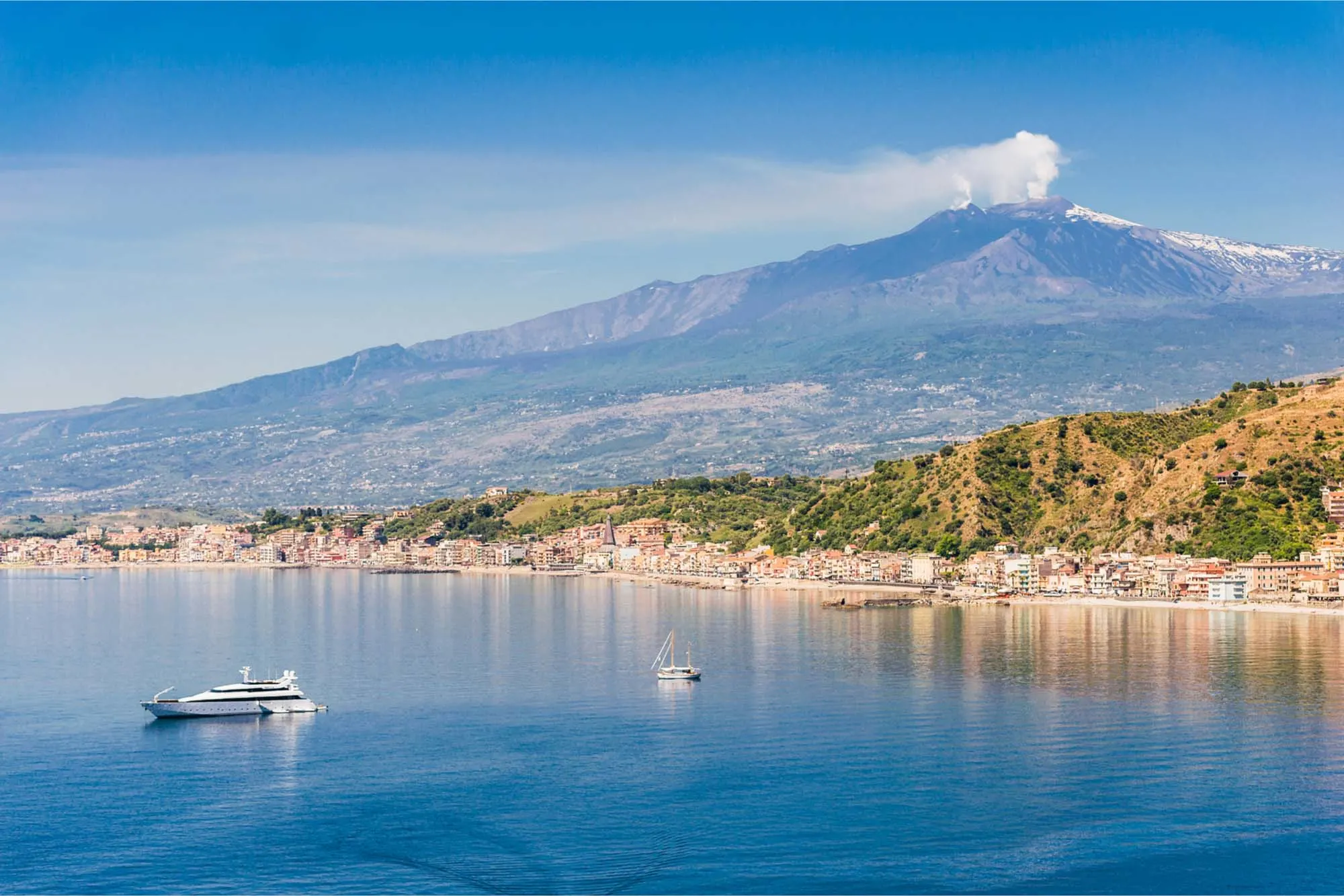 Mount Etna towering near the coast and ocean