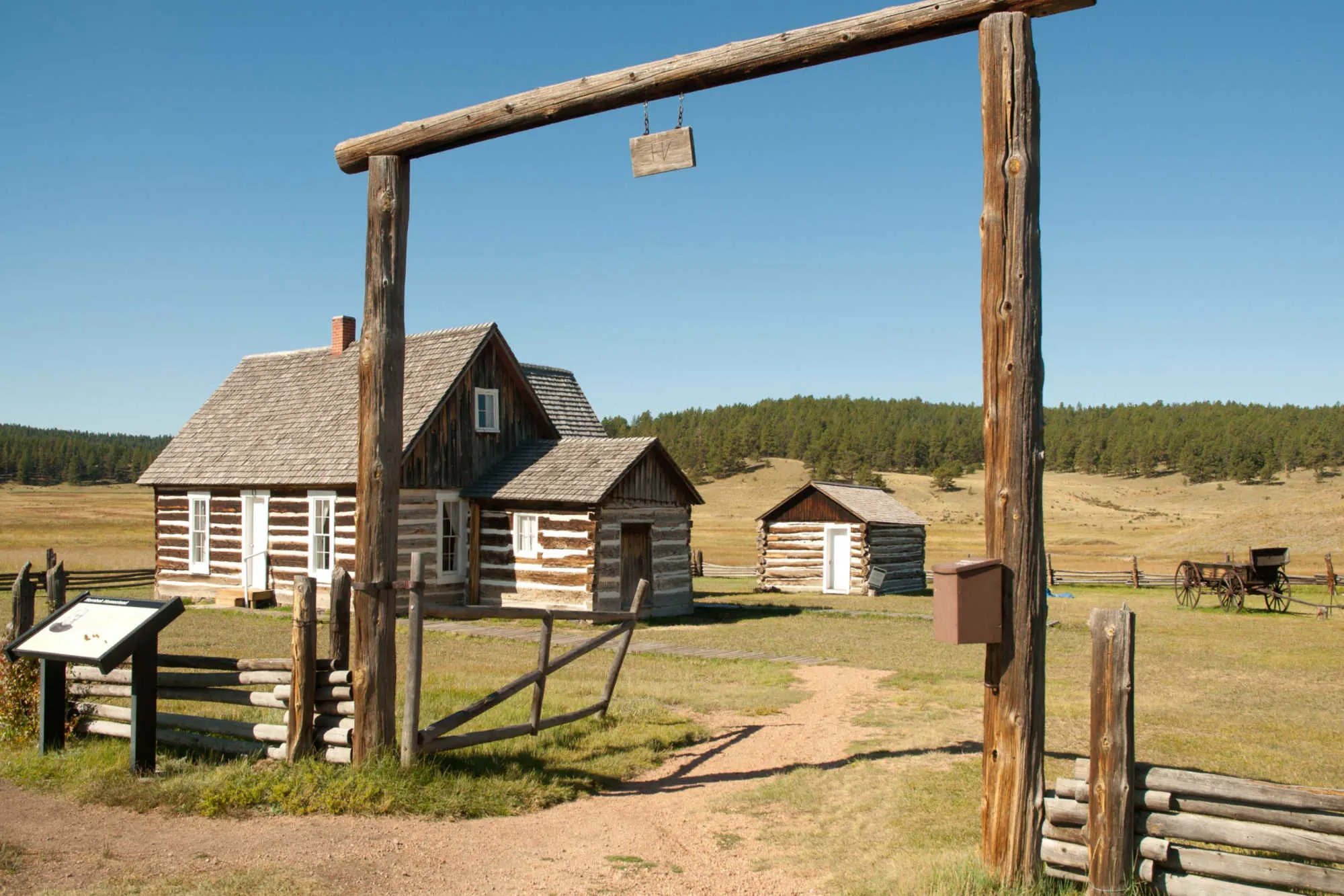 Log cabins inside wooden fence enclosure at Hornbek Homestead