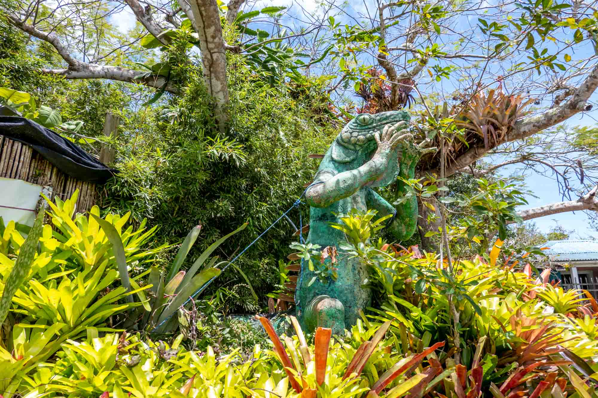 Lizard stature surrounded by plants and trees