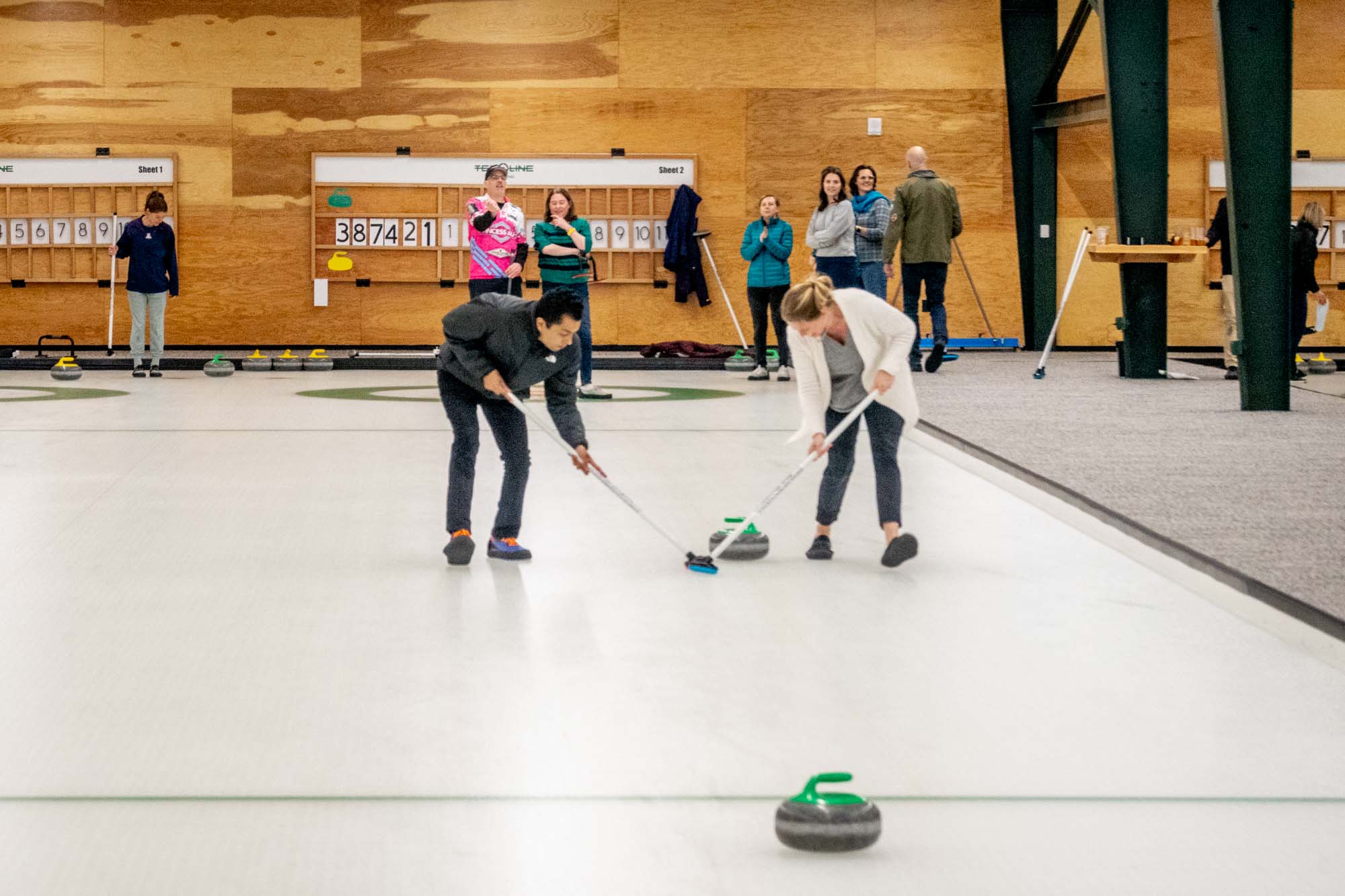 People curling stones on an ice rink